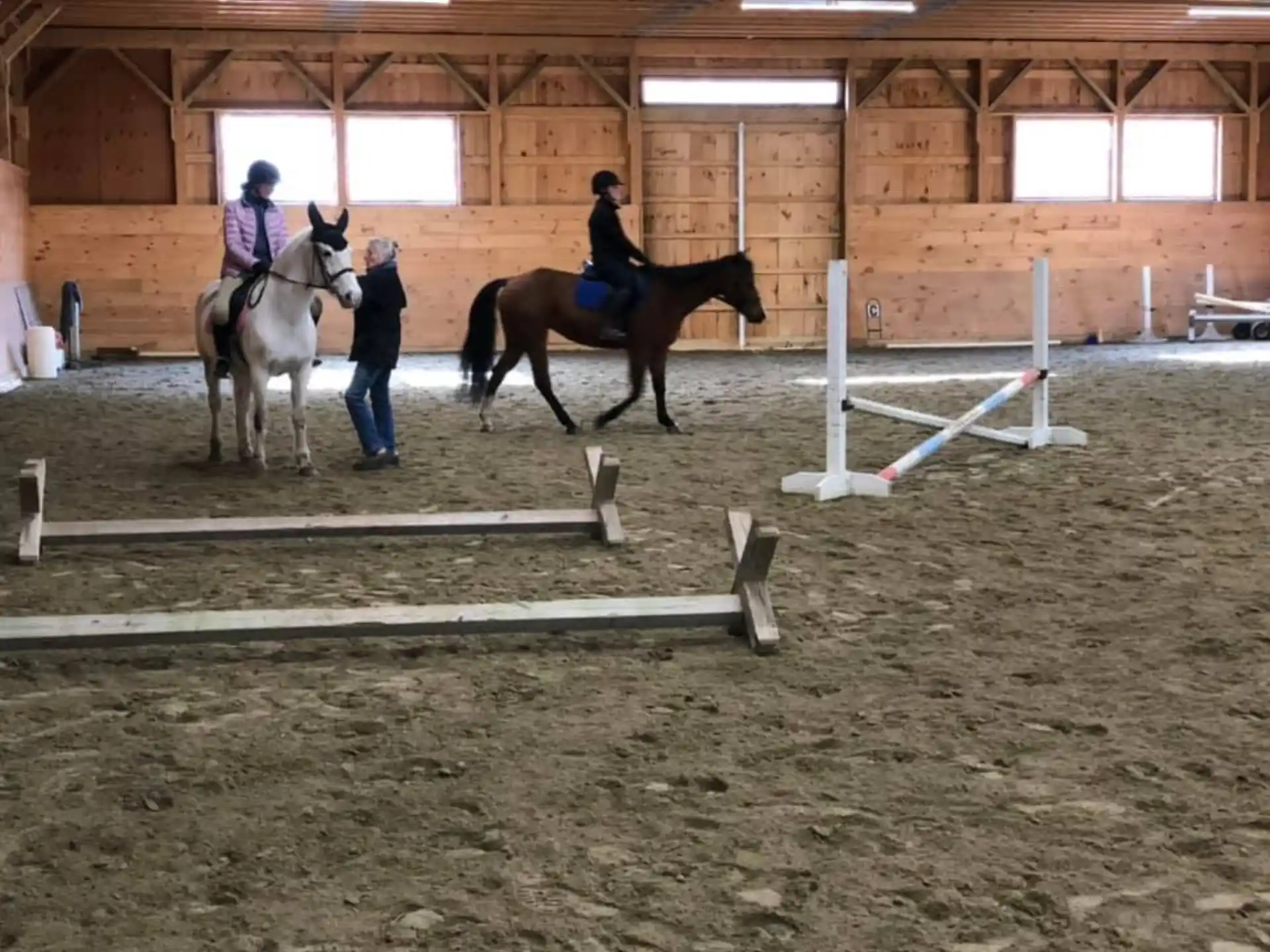 a group of people riding horses in a barn