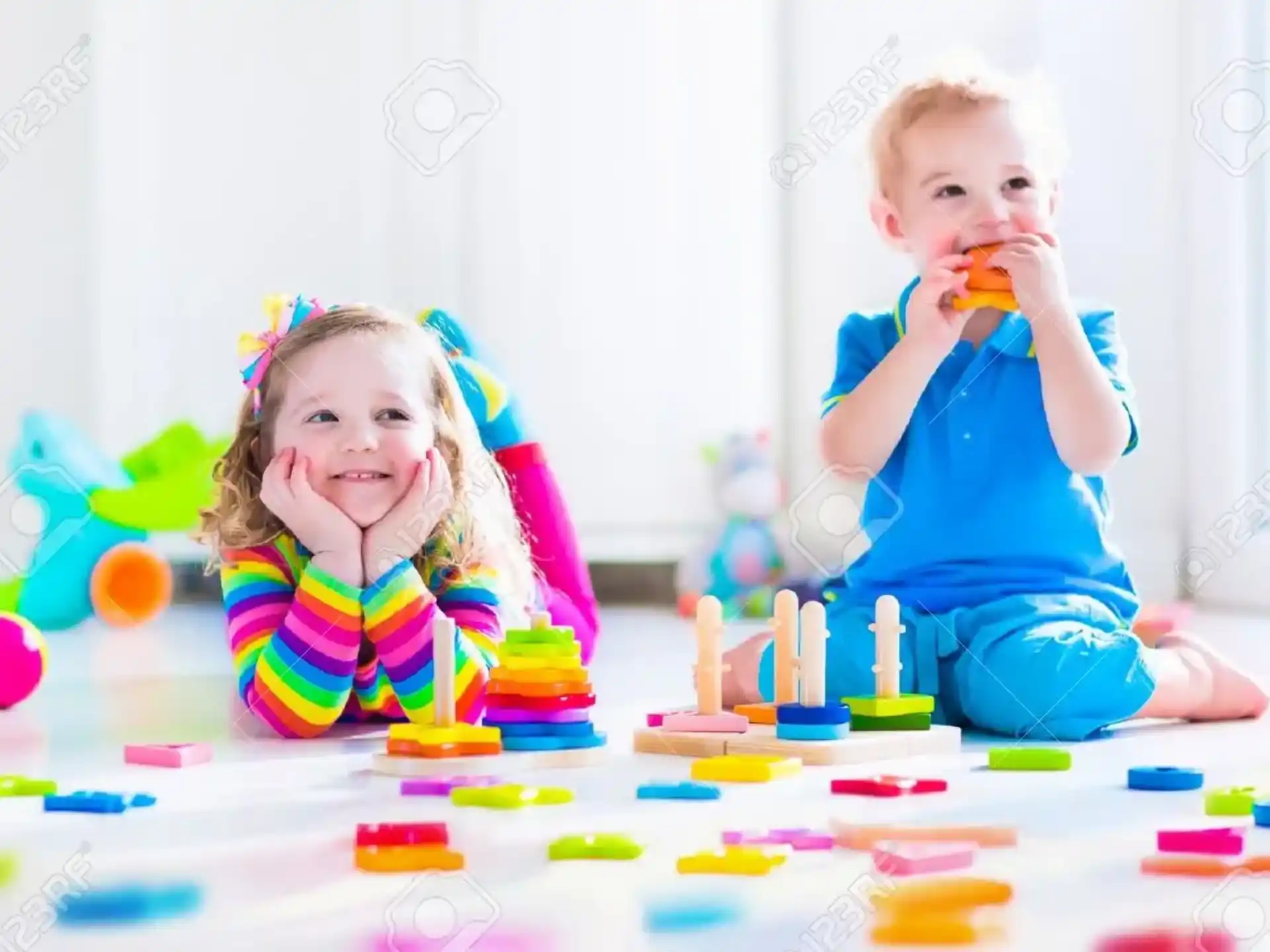 a couple of children sitting at a table with toys