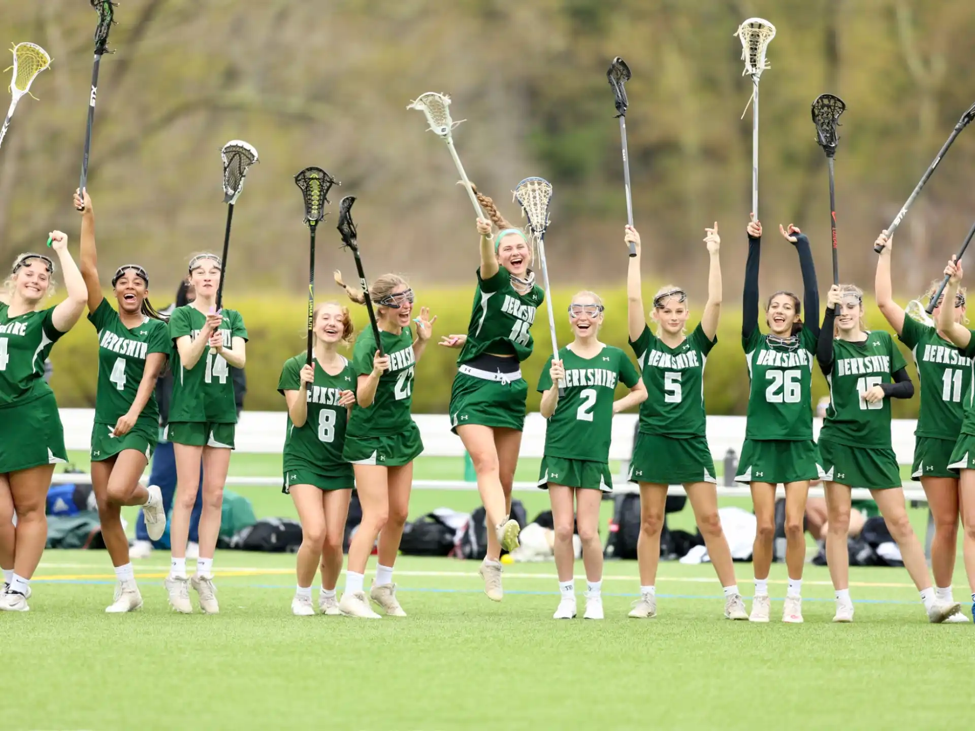 a group of people in green uniforms holding a trophy