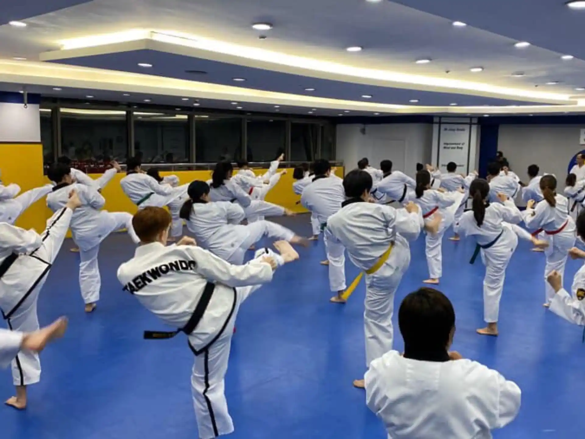 a group of people in white karate uniforms in a room