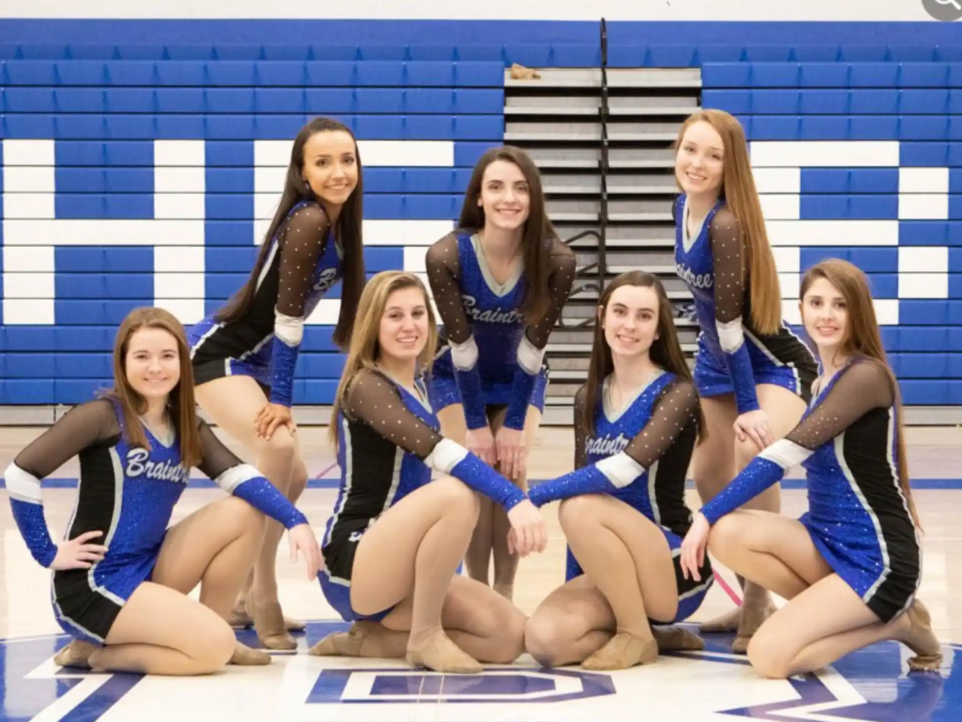 a group of women in leotards posing for a photo