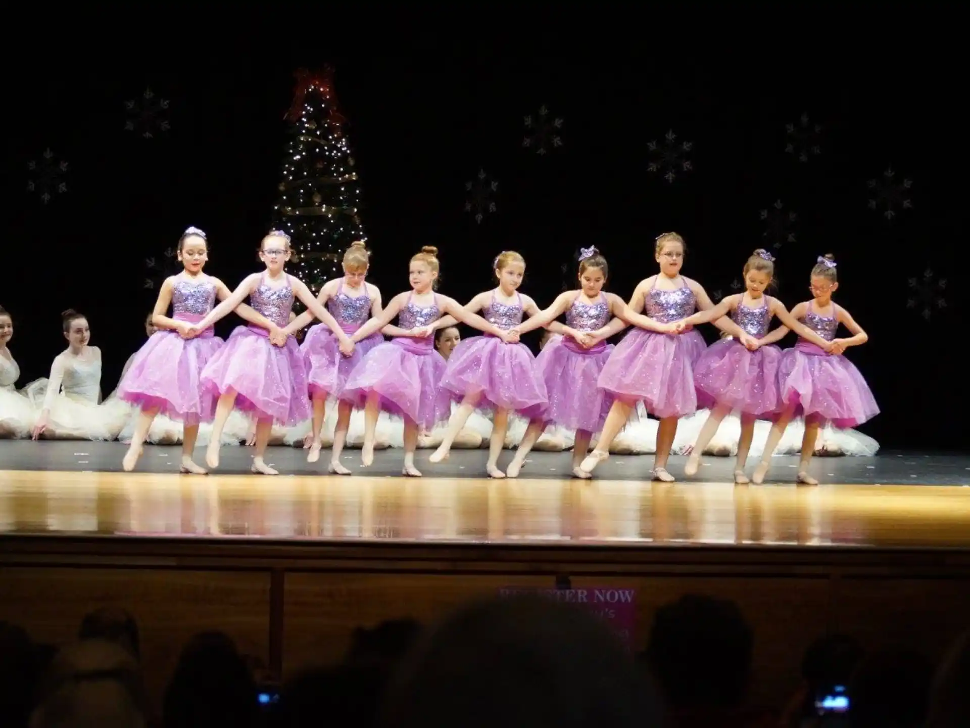 a group of women in dresses on a stage