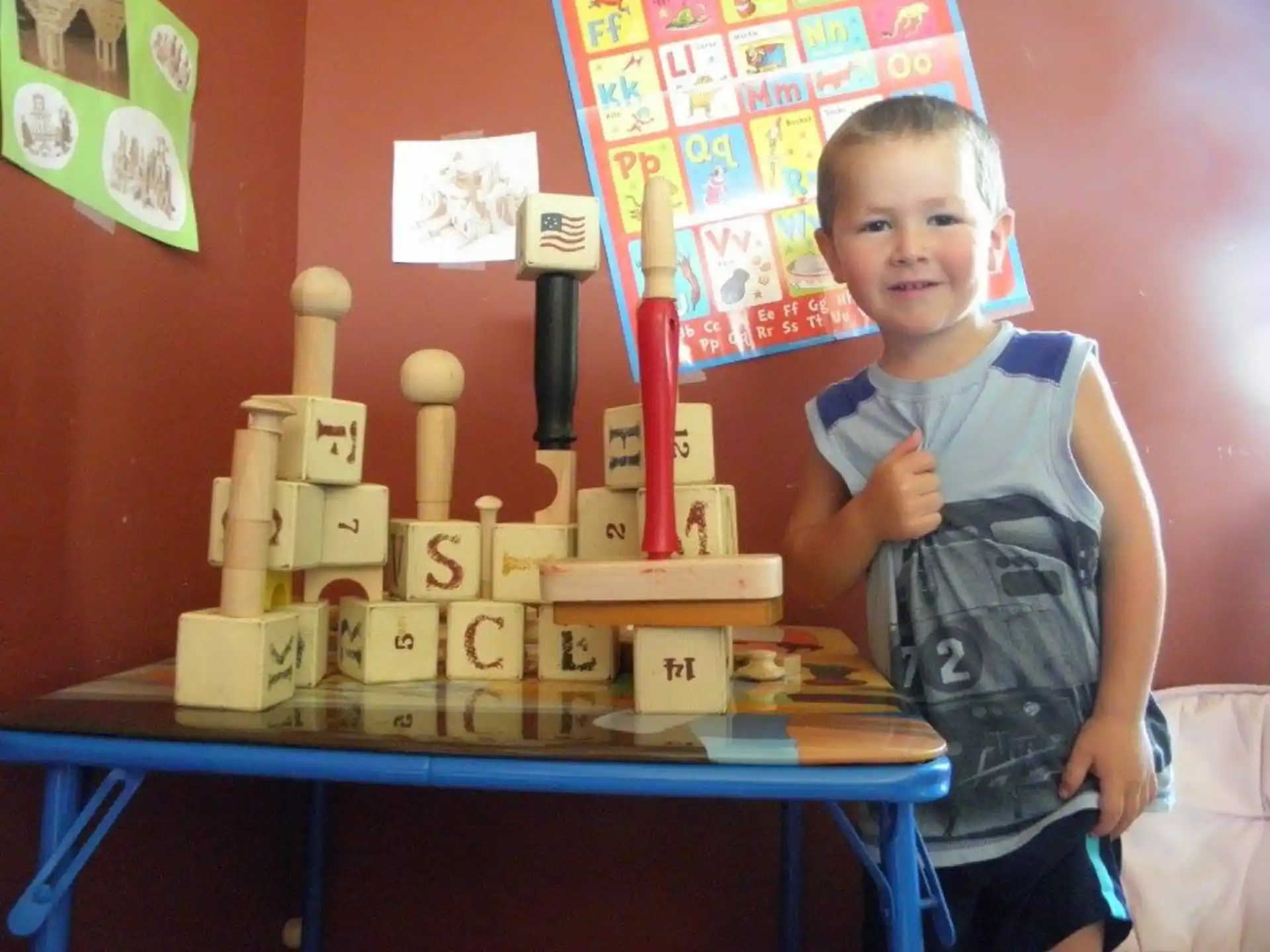 a boy standing next to a table with boxes on it
