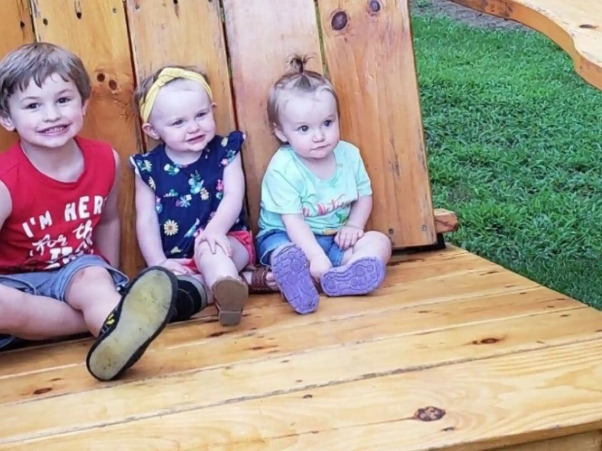 a group of children sitting in a wooden chair