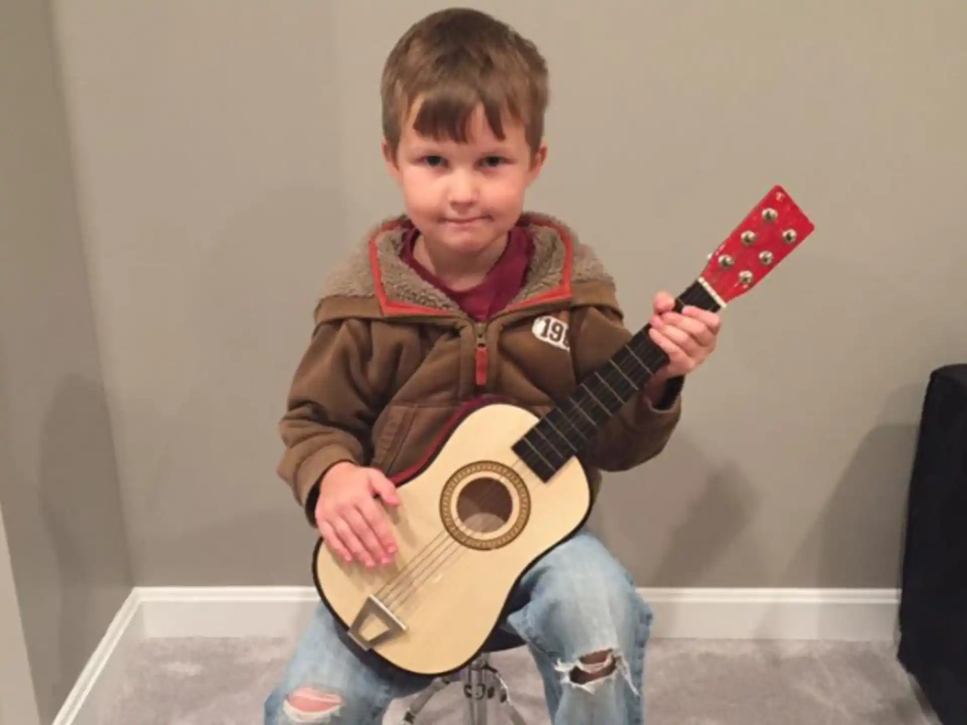 a boy holding a guitar