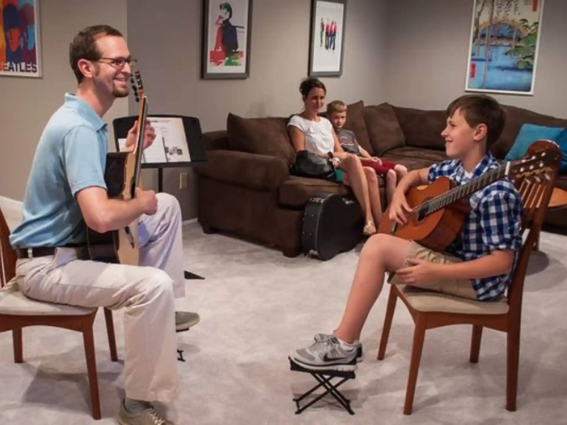 a person playing a guitar to a group of people sitting in chairs