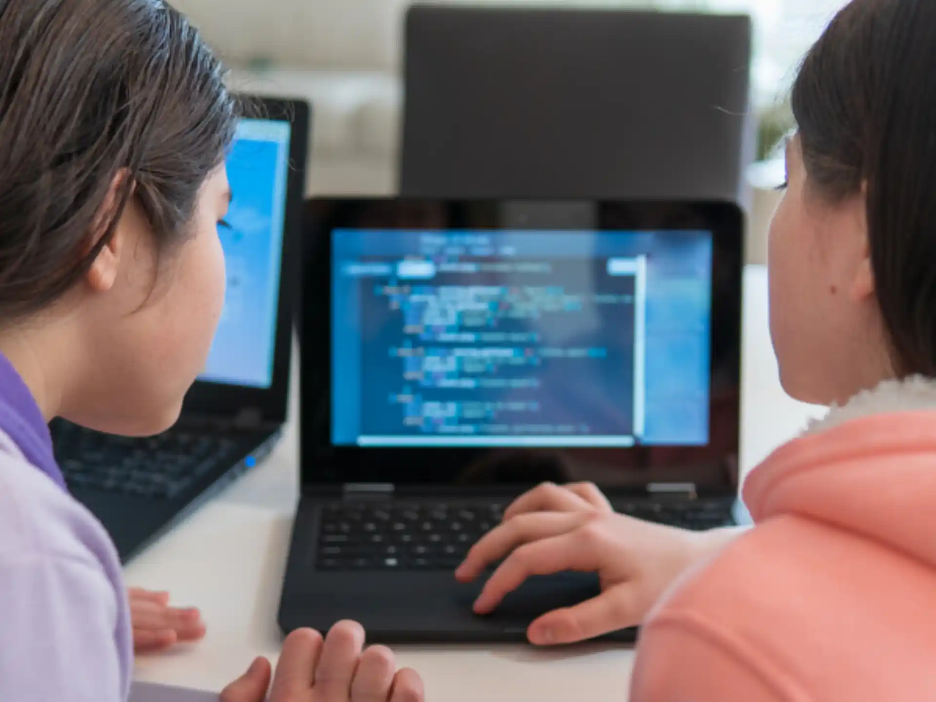 a woman and a child using a laptop