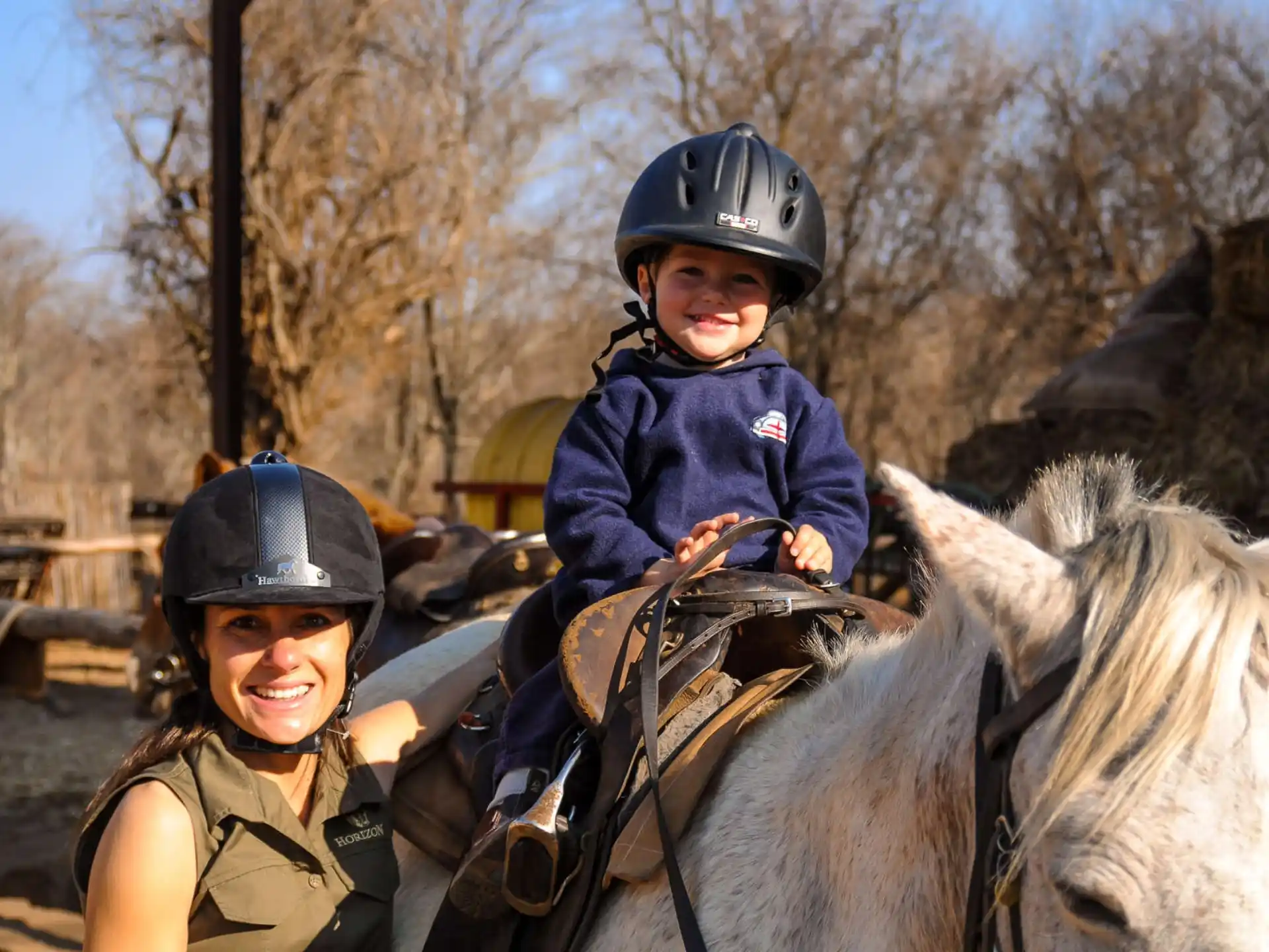 a person and a child riding a horse