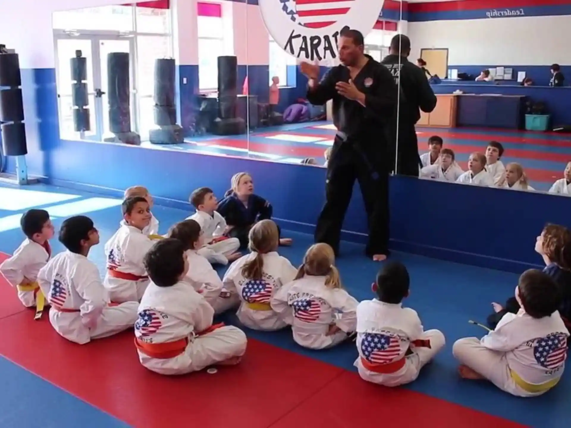 a person standing in front of a group of people sitting on the floor
