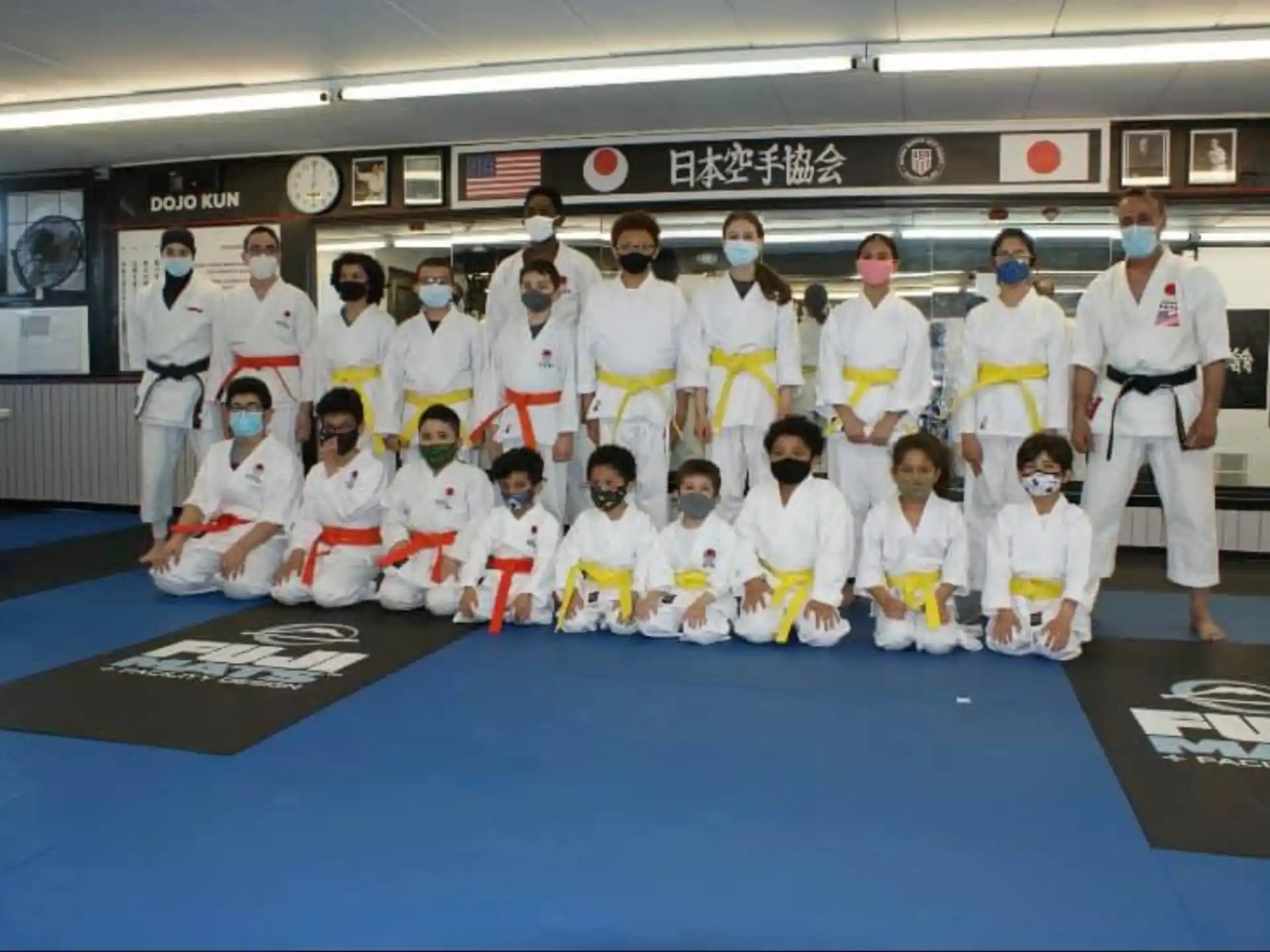a group of people in white karate uniforms posing for a photo