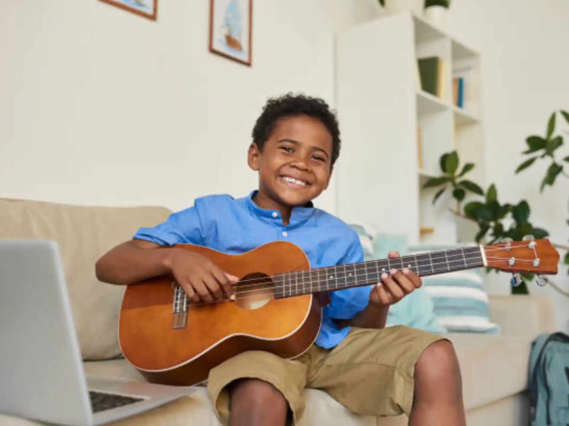 a person sitting on a couch playing a guitar