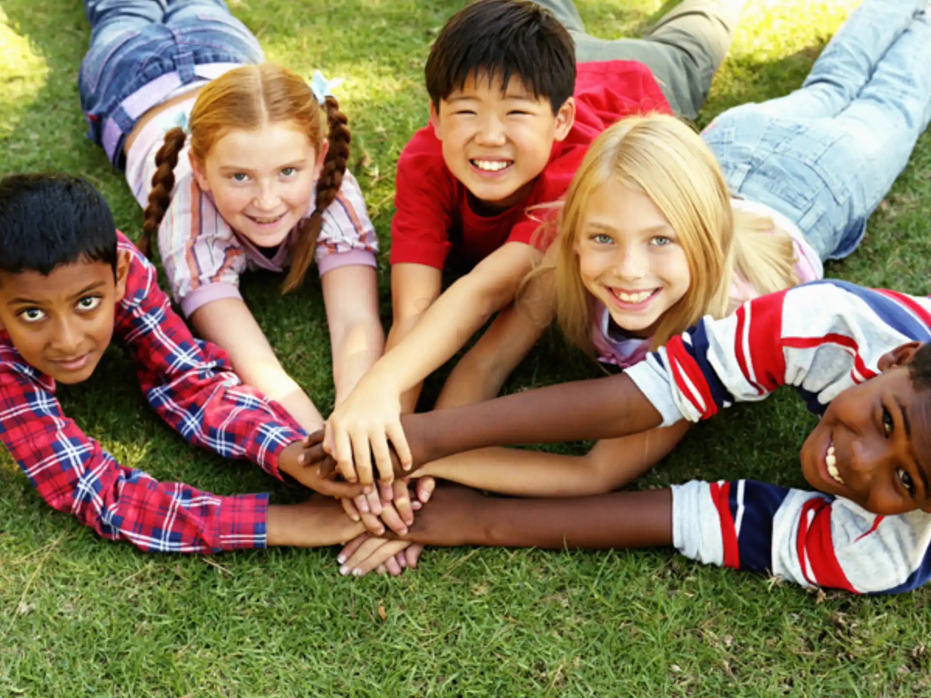 a group of children lying on the grass
