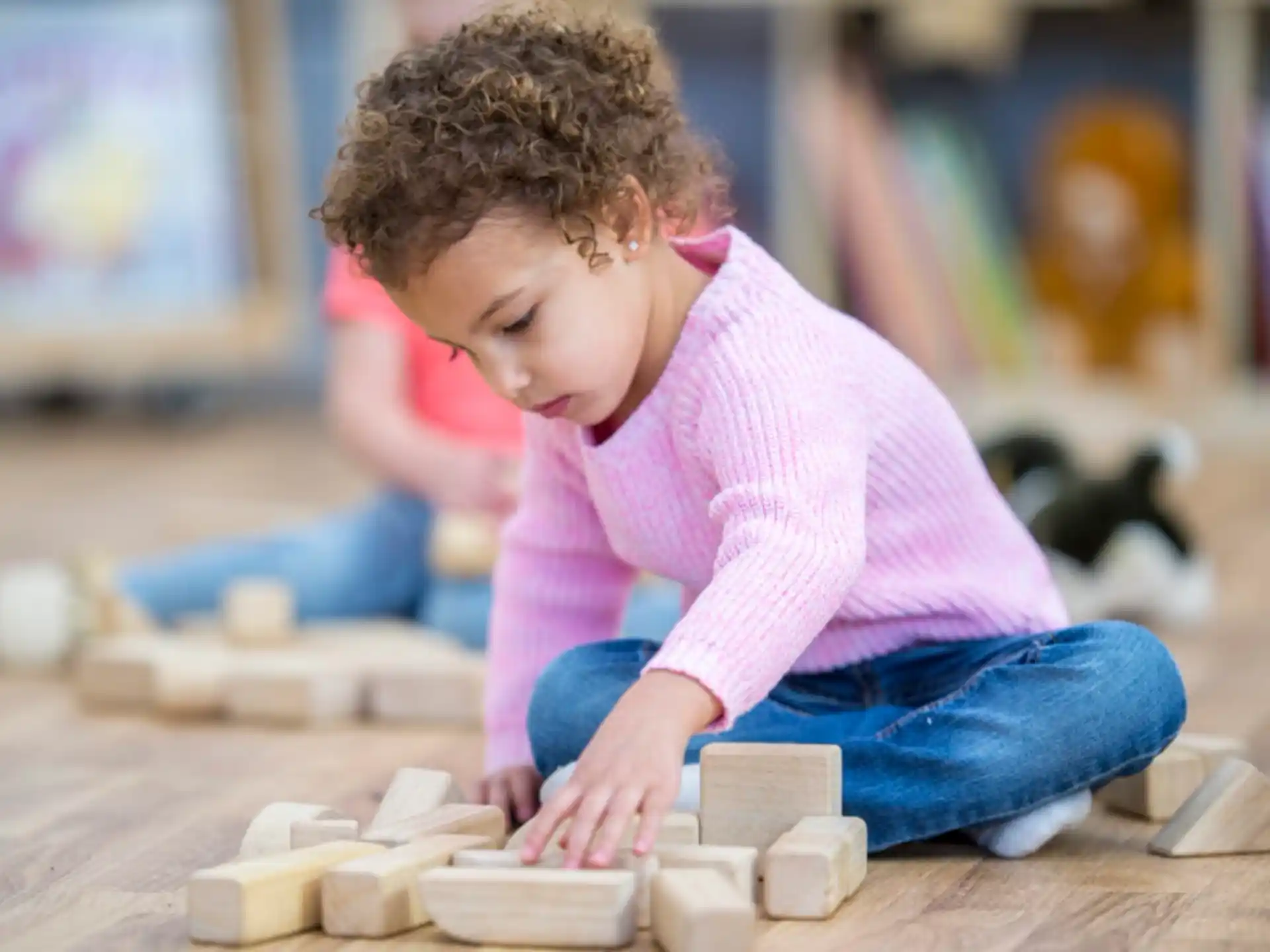 a young girl playing with wooden blocks