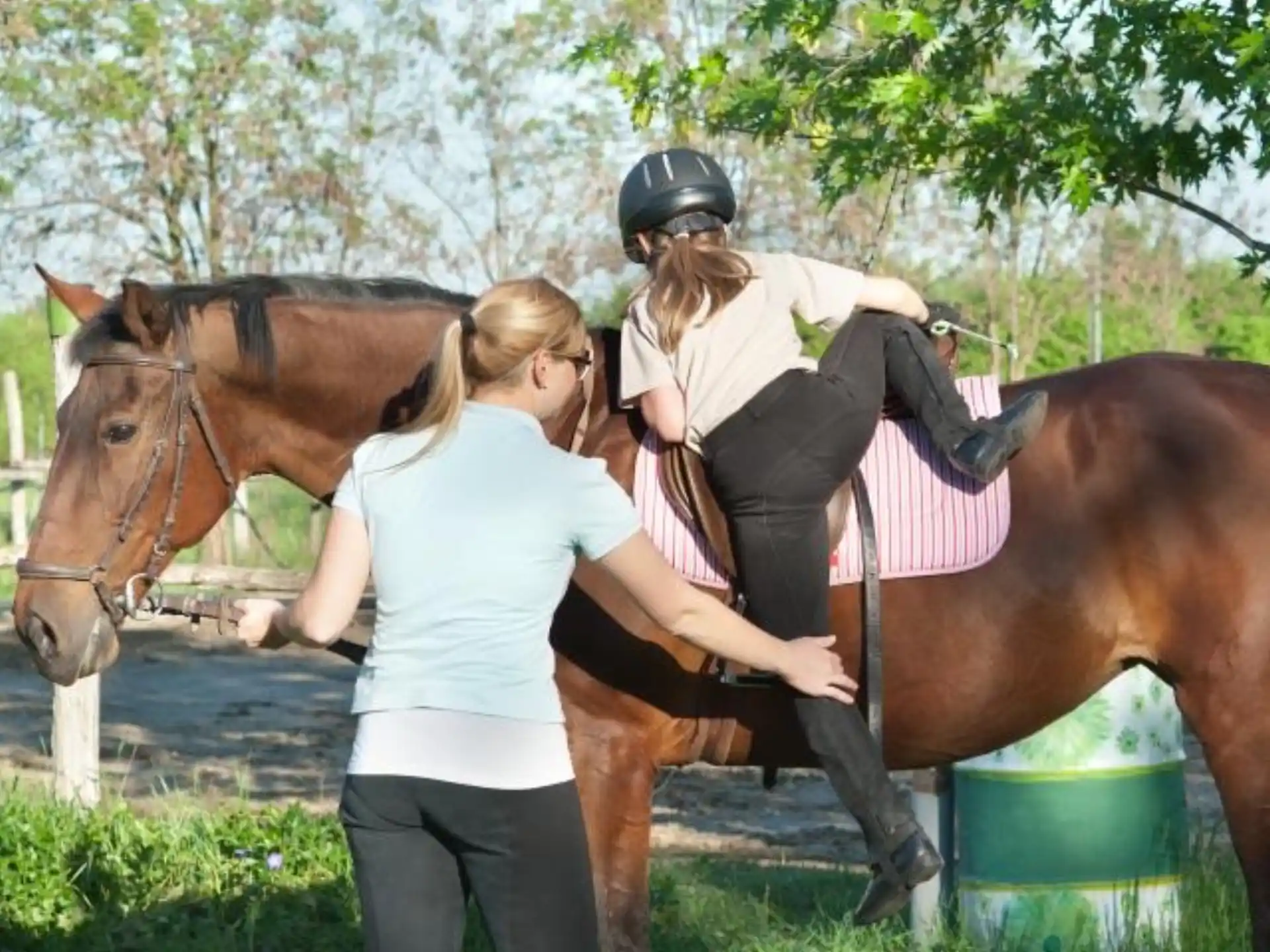 a woman riding a horse with another woman on the back
