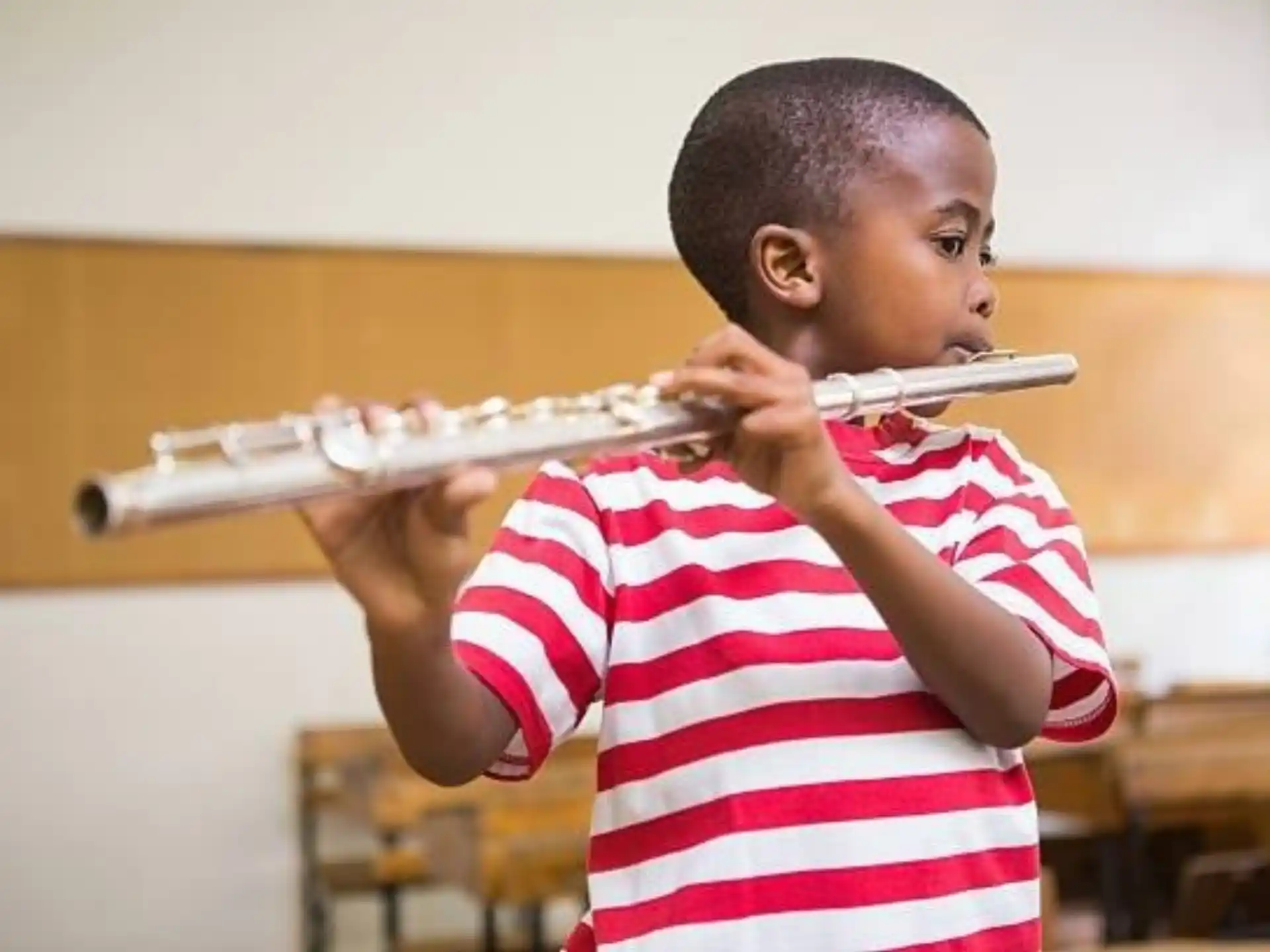 a young boy playing a flute