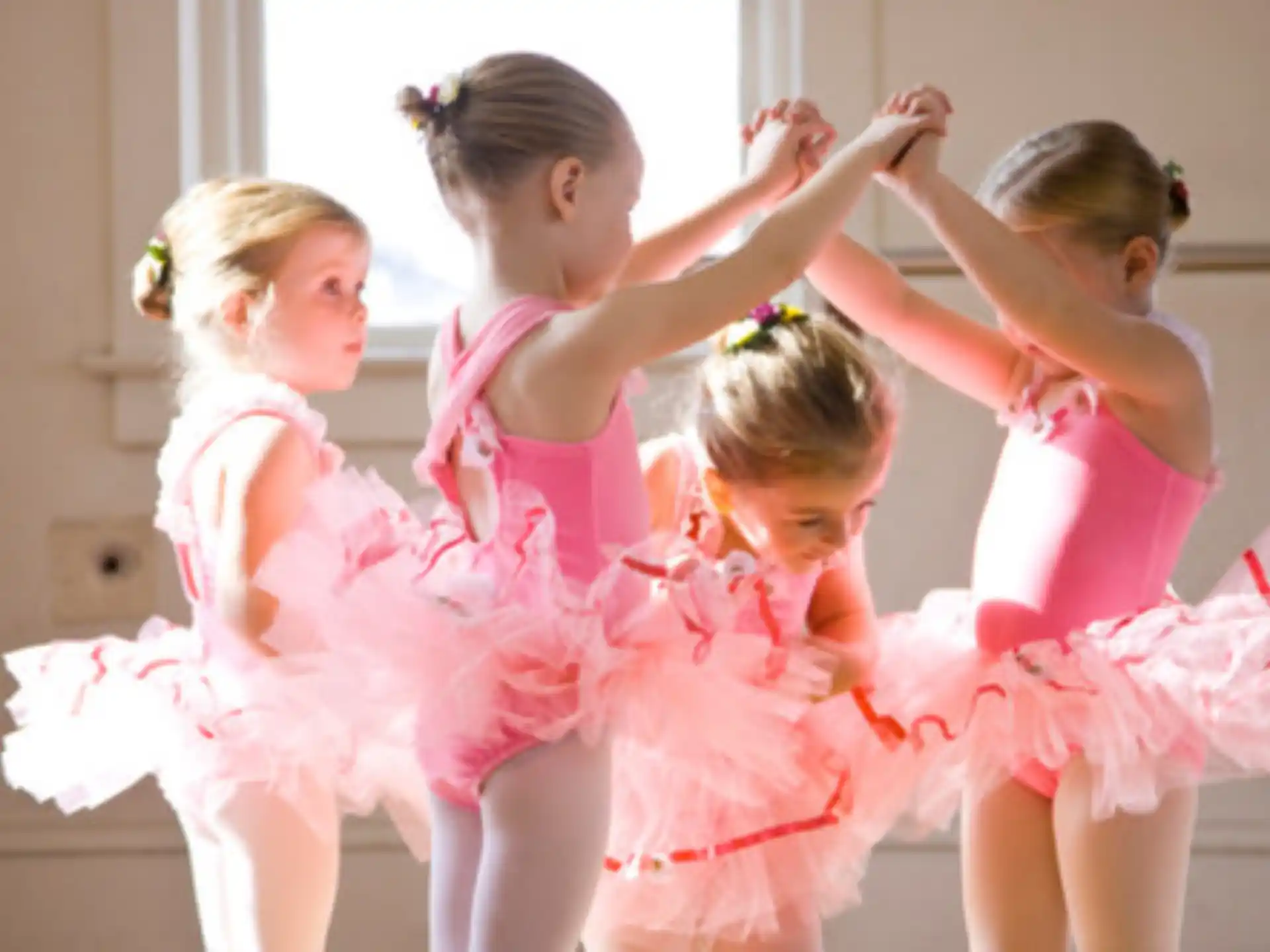 a group of girls in dresses dancing