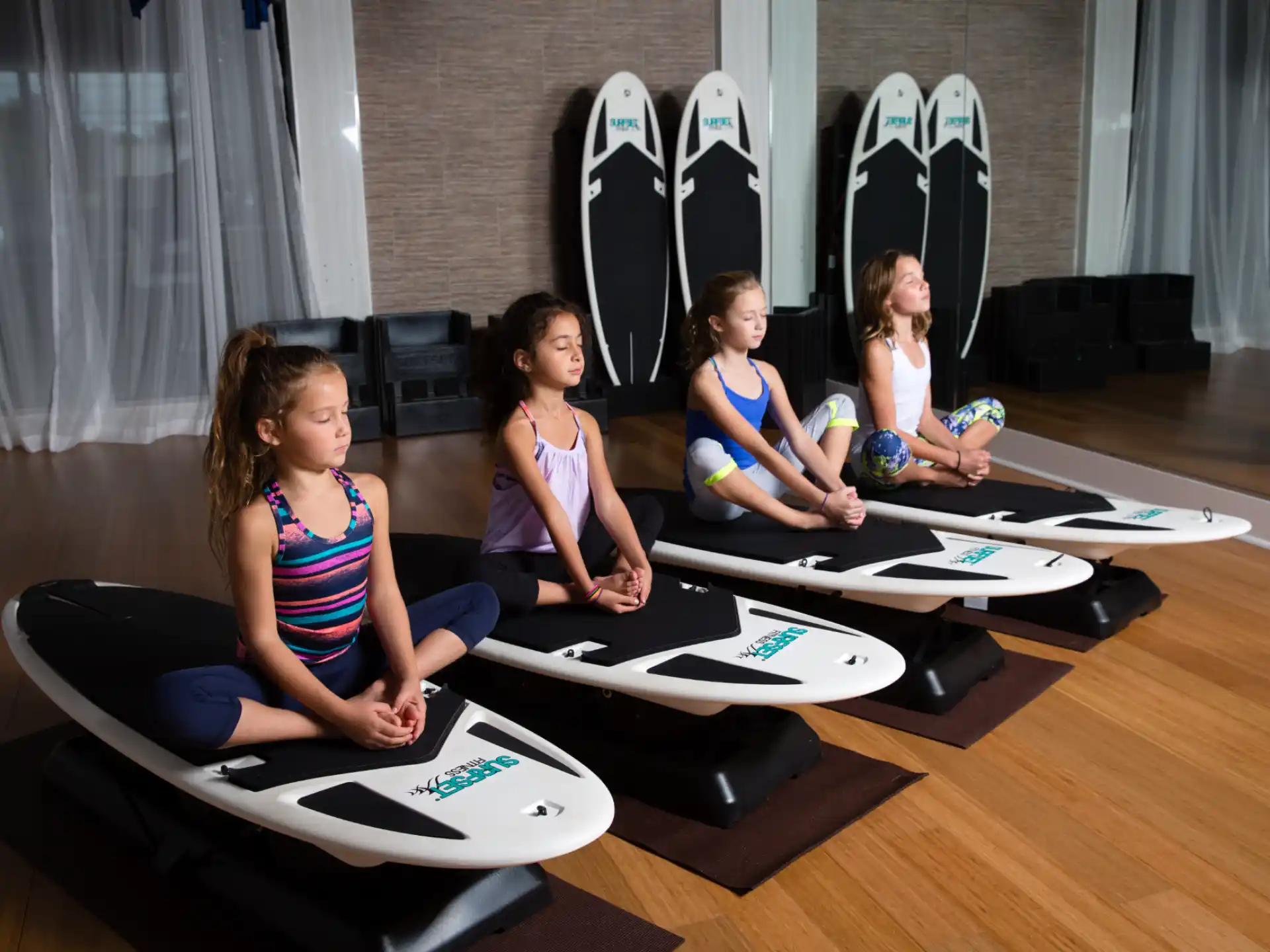a group of girls sitting on yoga mats