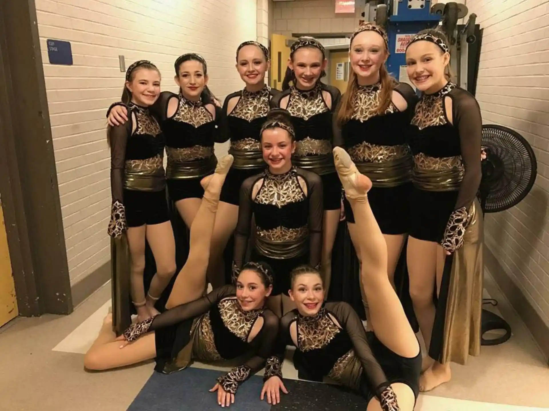 a group of women in black and gold clothing
