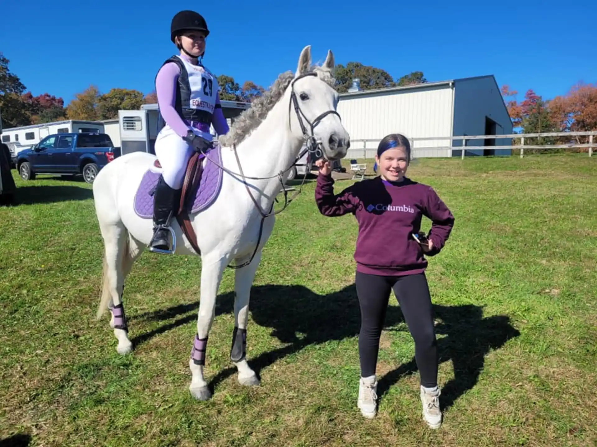 a person standing next to a girl on a horse