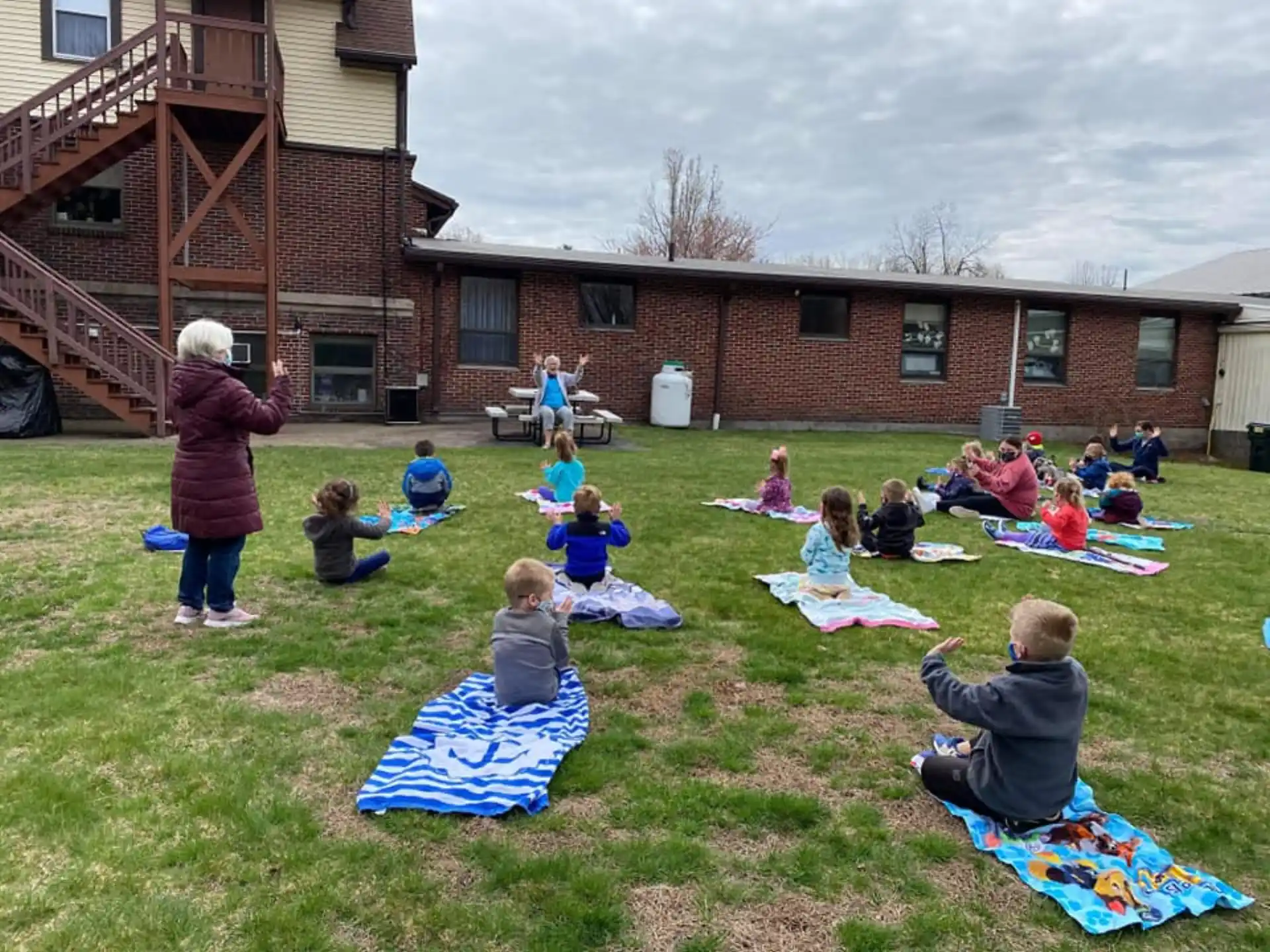 a group of children sitting on the grass