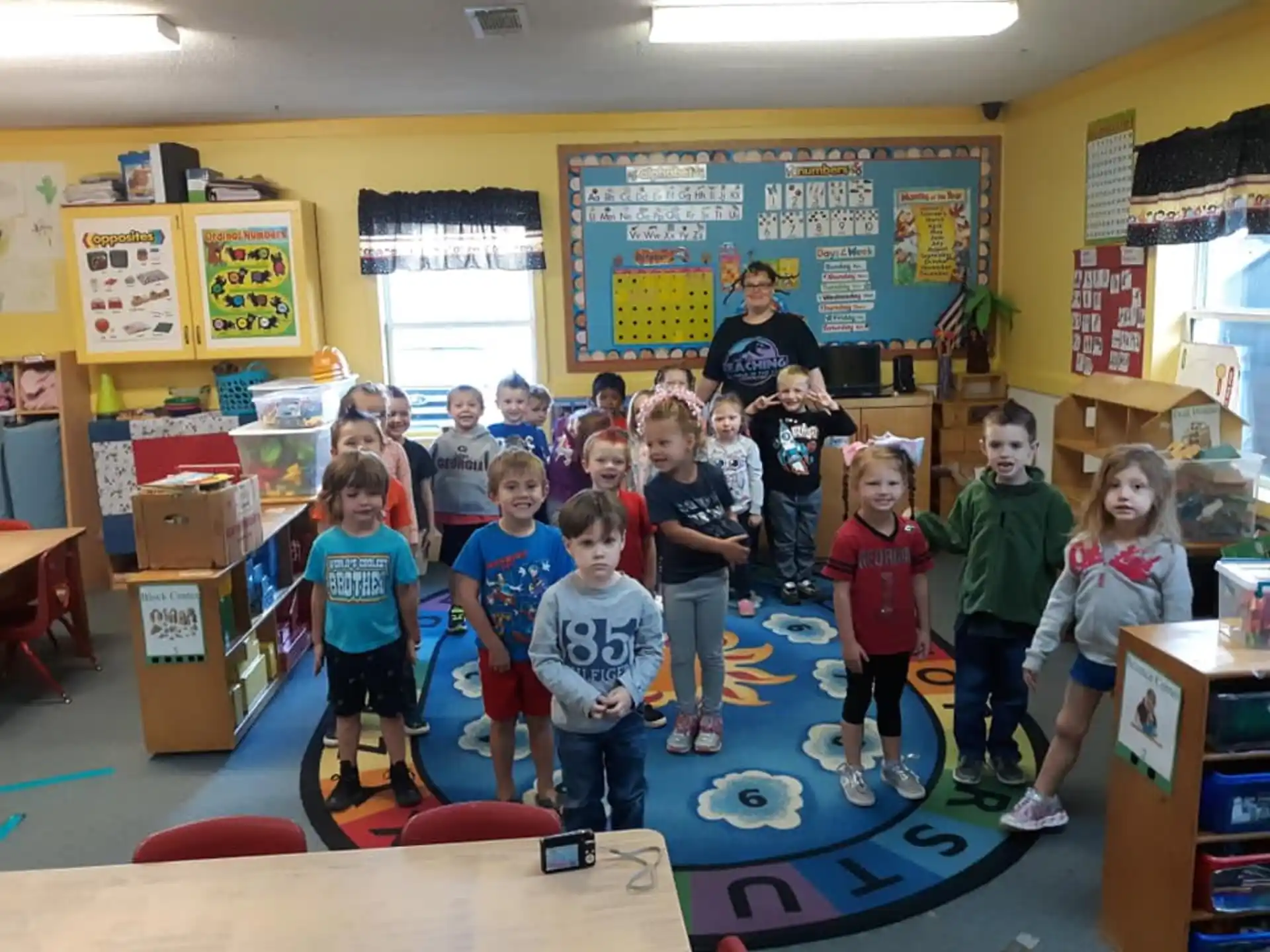 a group of children posing for a photo in a classroom