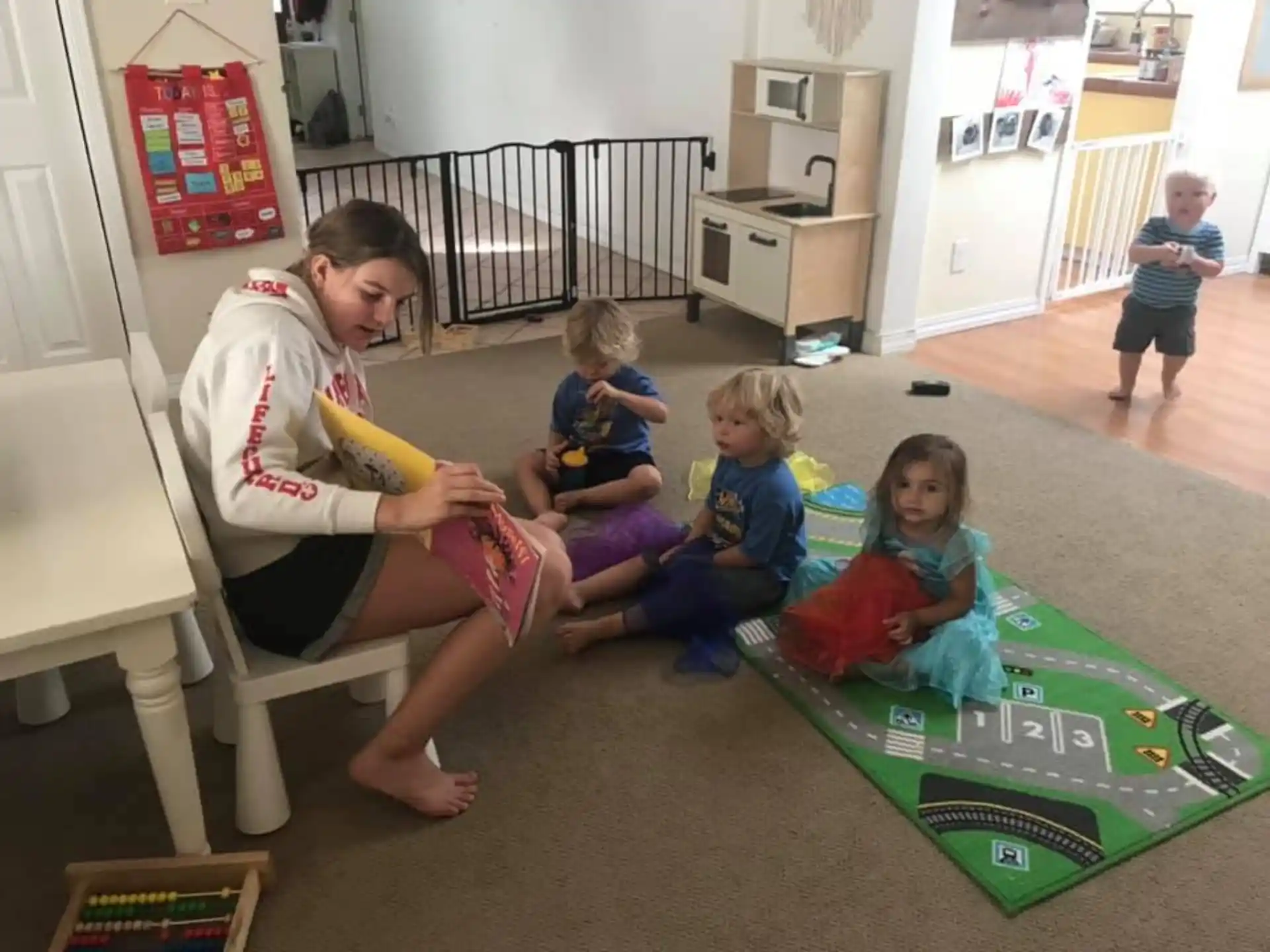 a person and children sitting on a green mat in a room