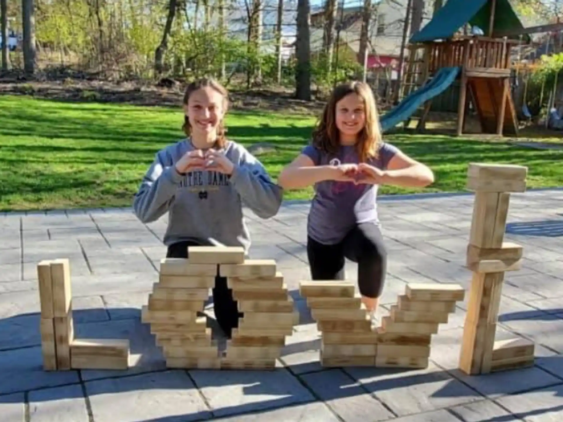 a person and a girl sitting on a wooden bench