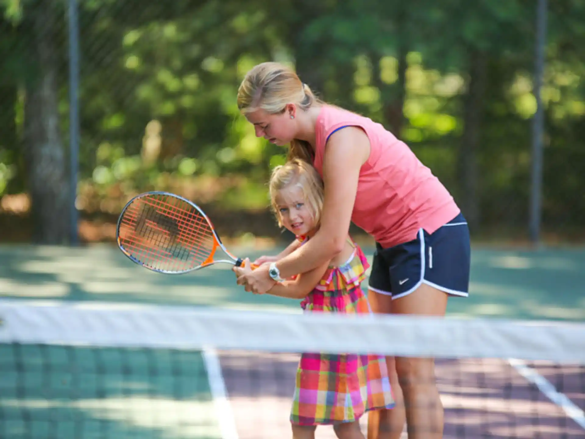 a person and a girl playing tennis