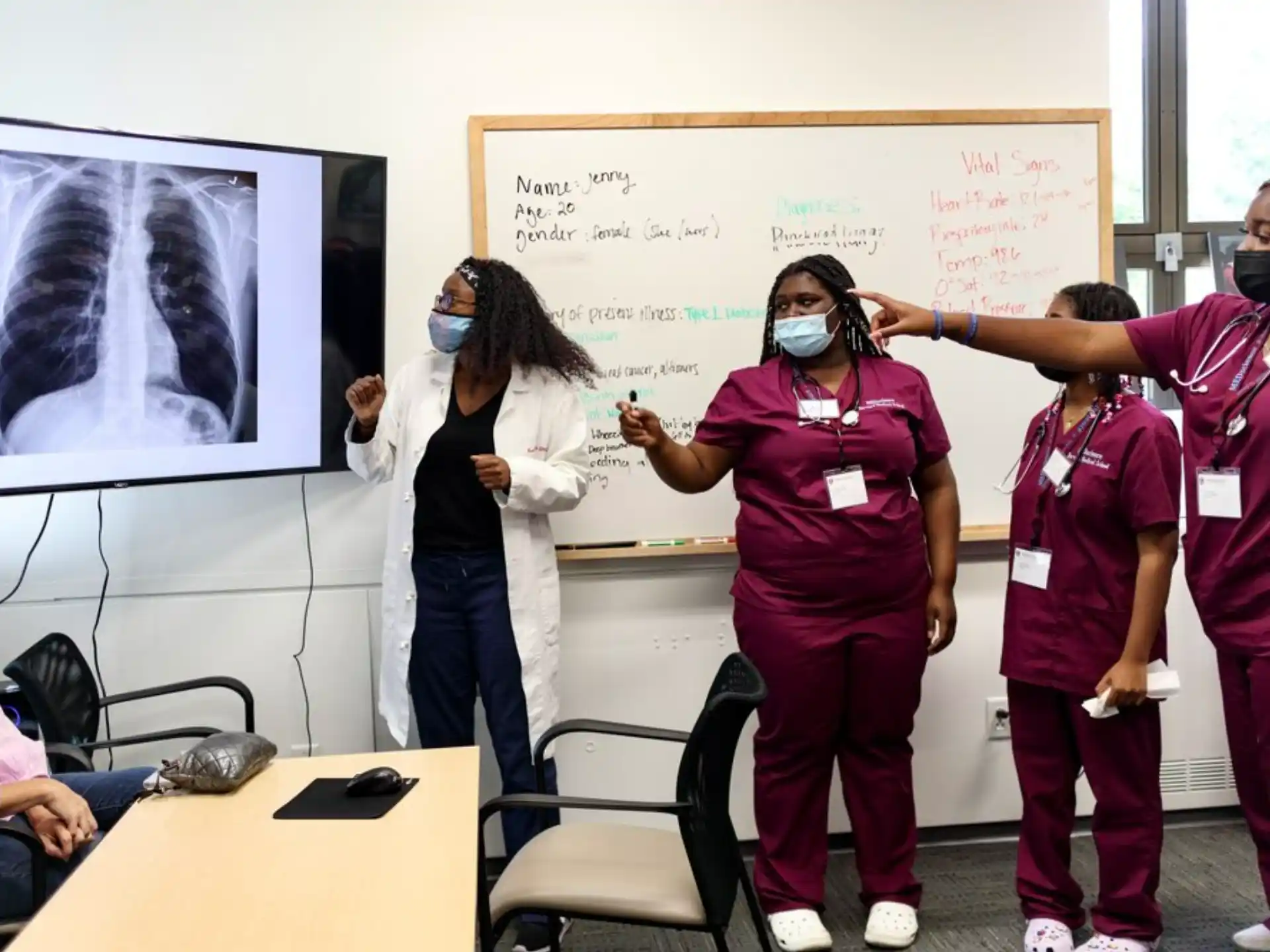 a group of people standing in front of a whiteboard