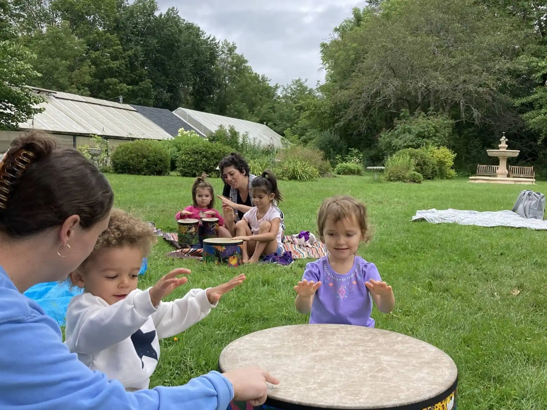 a person and a group of children playing in a grassy area