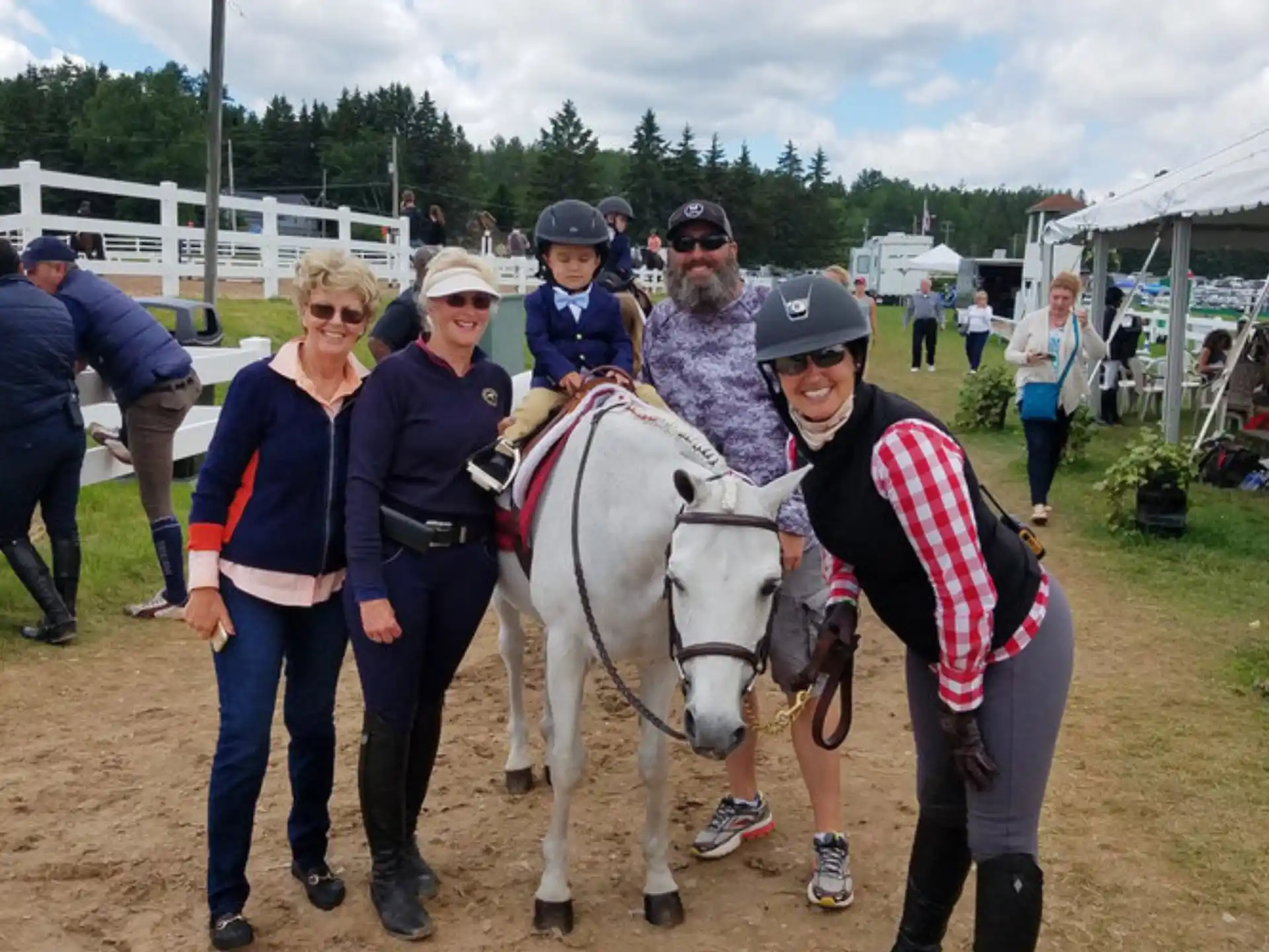 a group of people posing with a horse