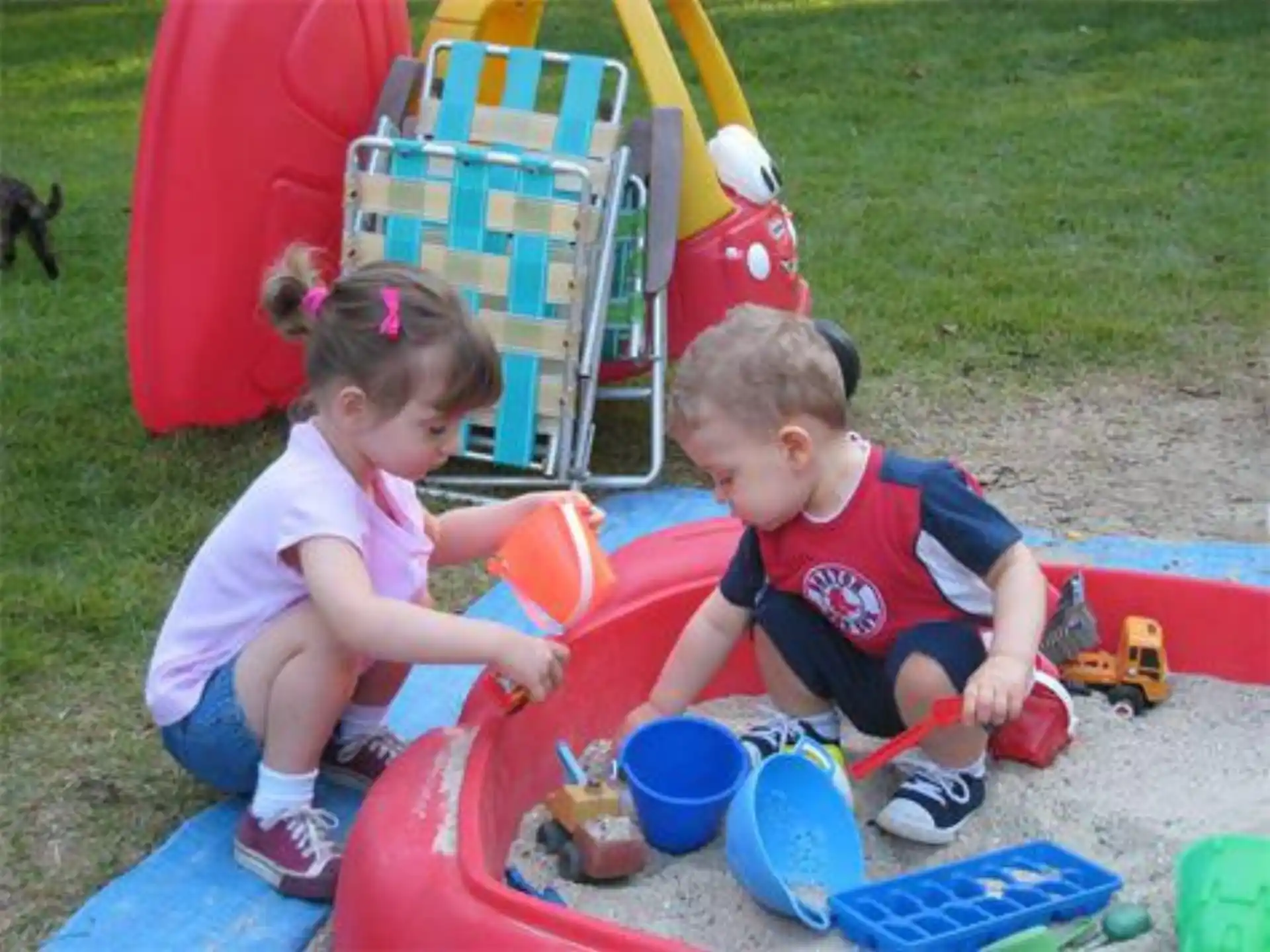 a couple of children playing in a sandbox