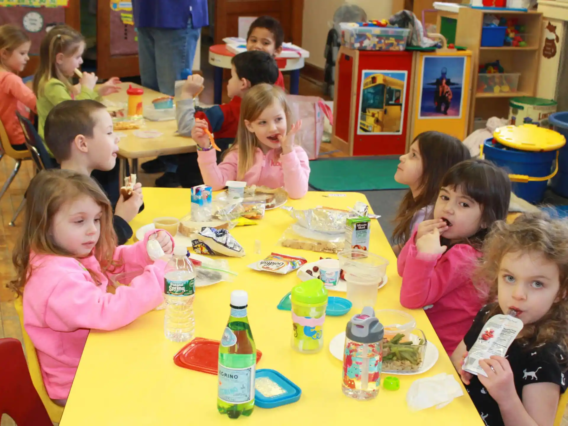 a group of children sitting at a table eating food