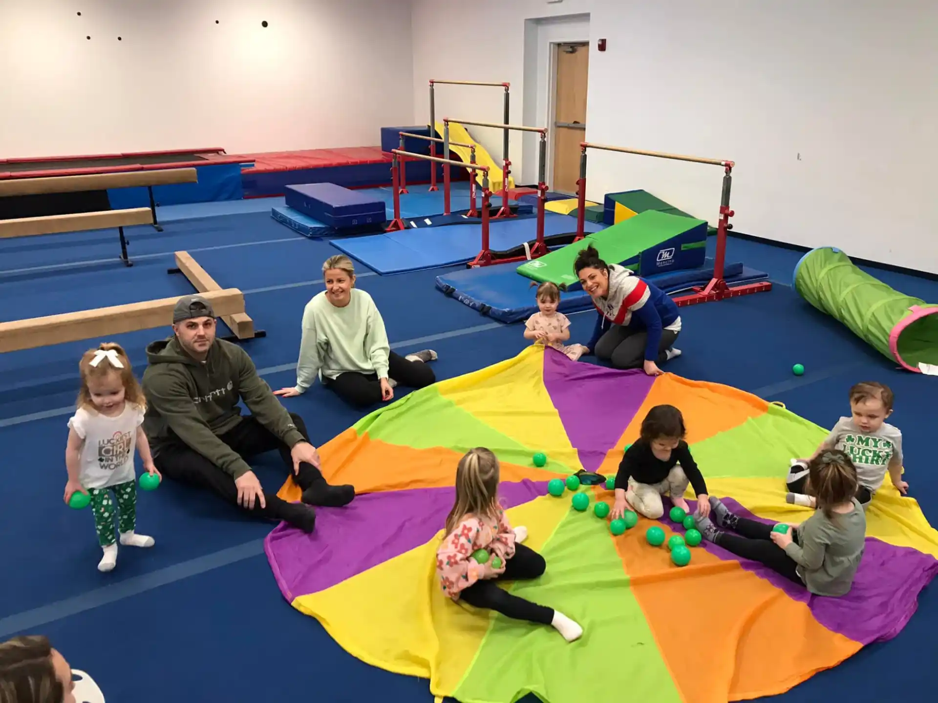 a group of people playing on a colorful mat in a room