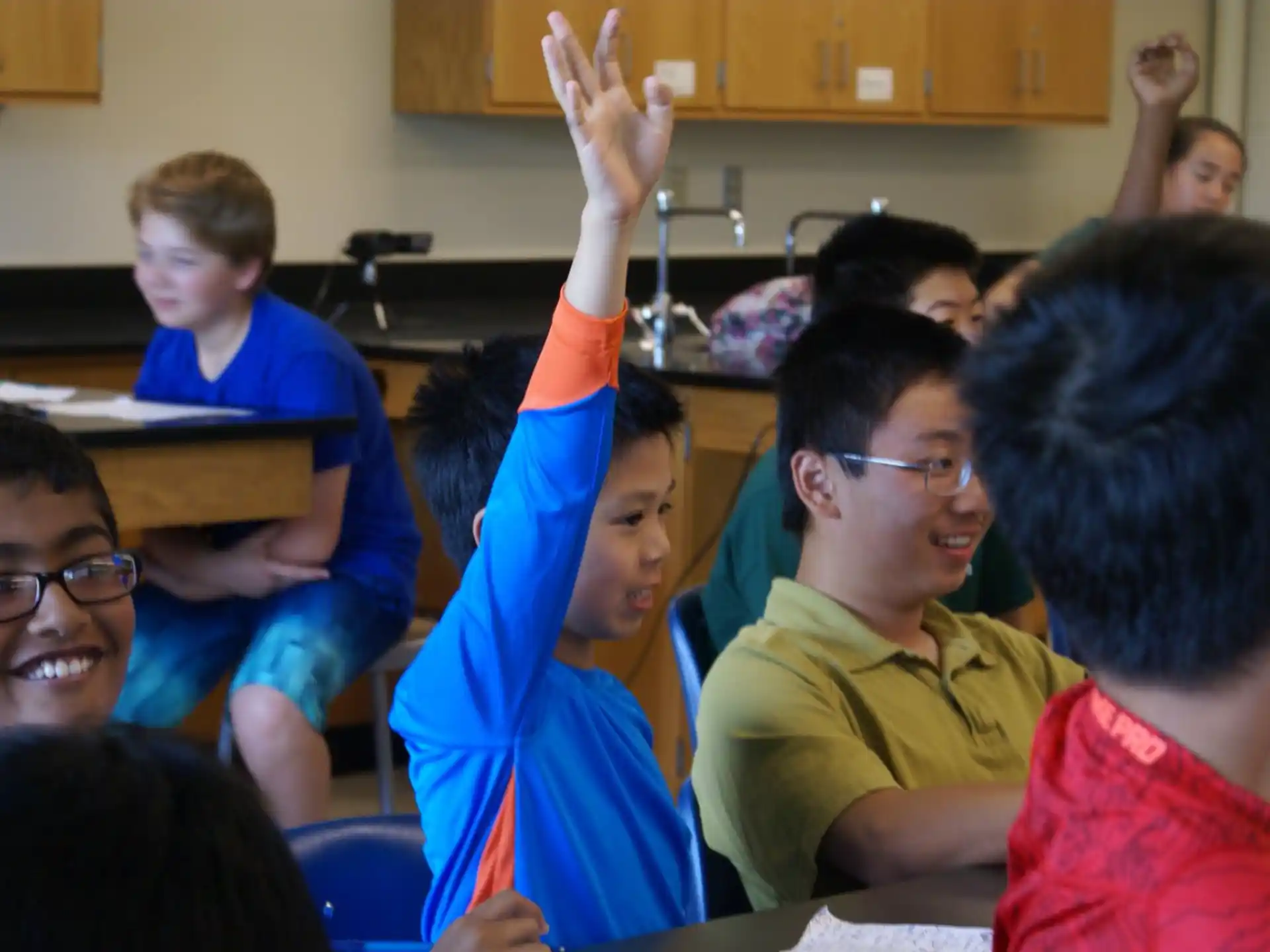 a group of children raising their hands