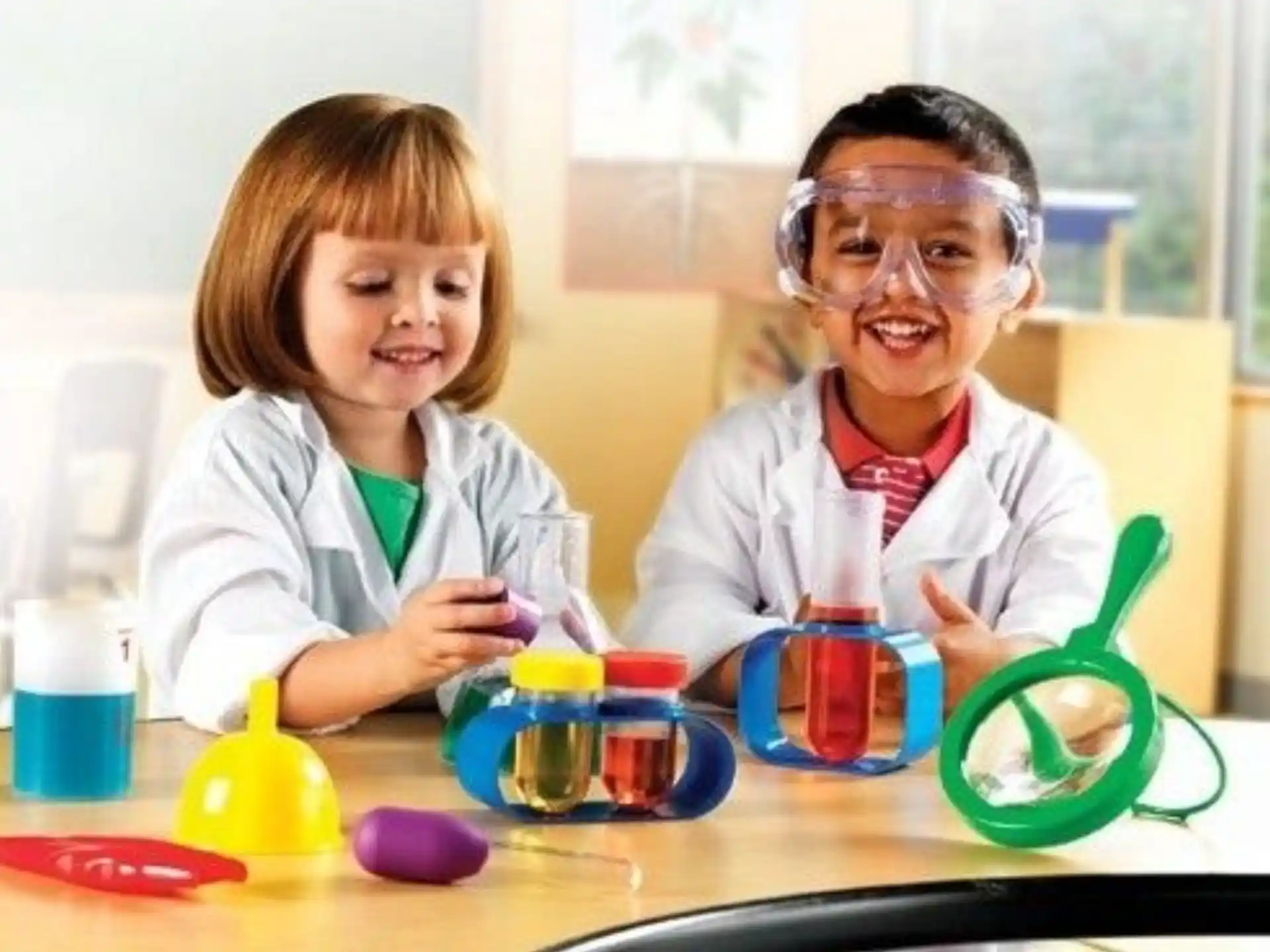 a person and a child wearing safety goggles and looking at a microscope