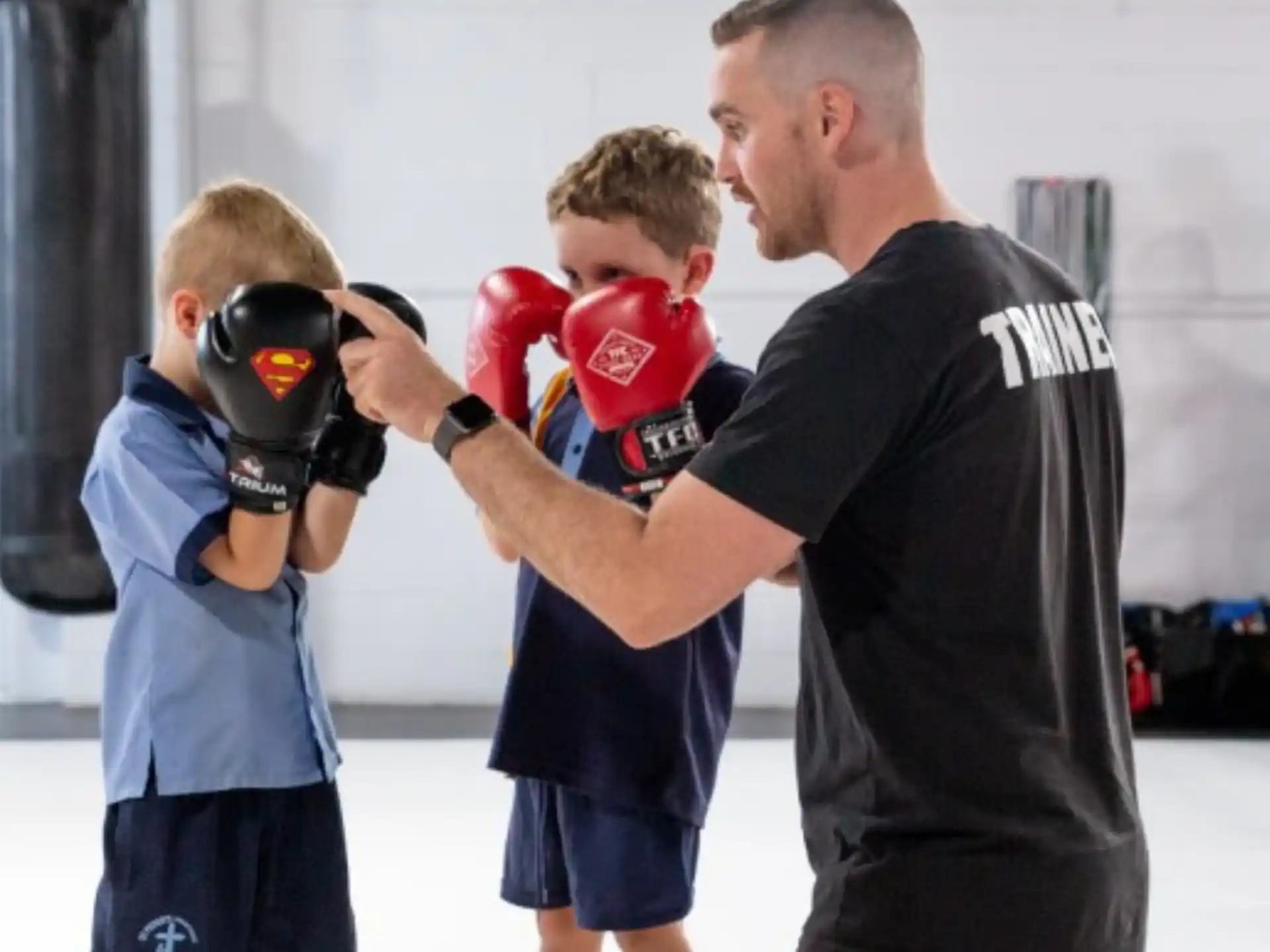 a man holding a boxing glove with a boy in the background