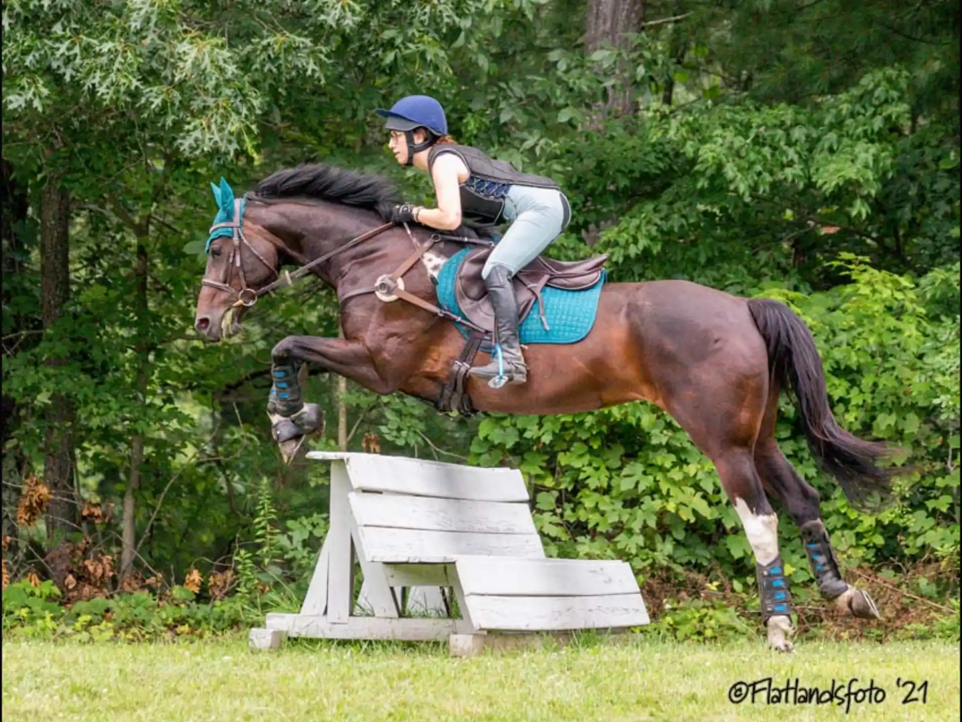 a person riding a horse over a jump