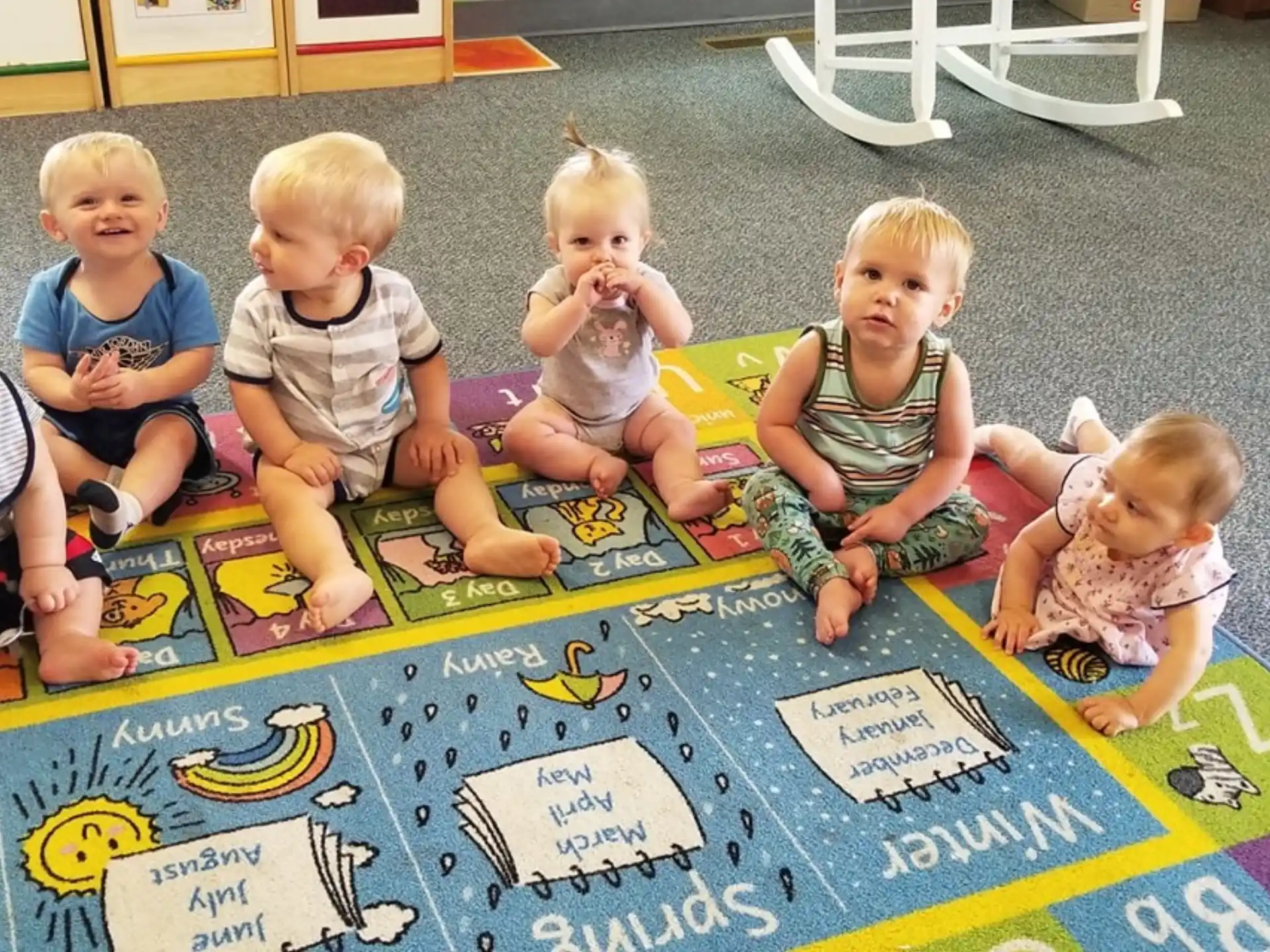 a group of children sitting on the floor playing with puzzle pieces