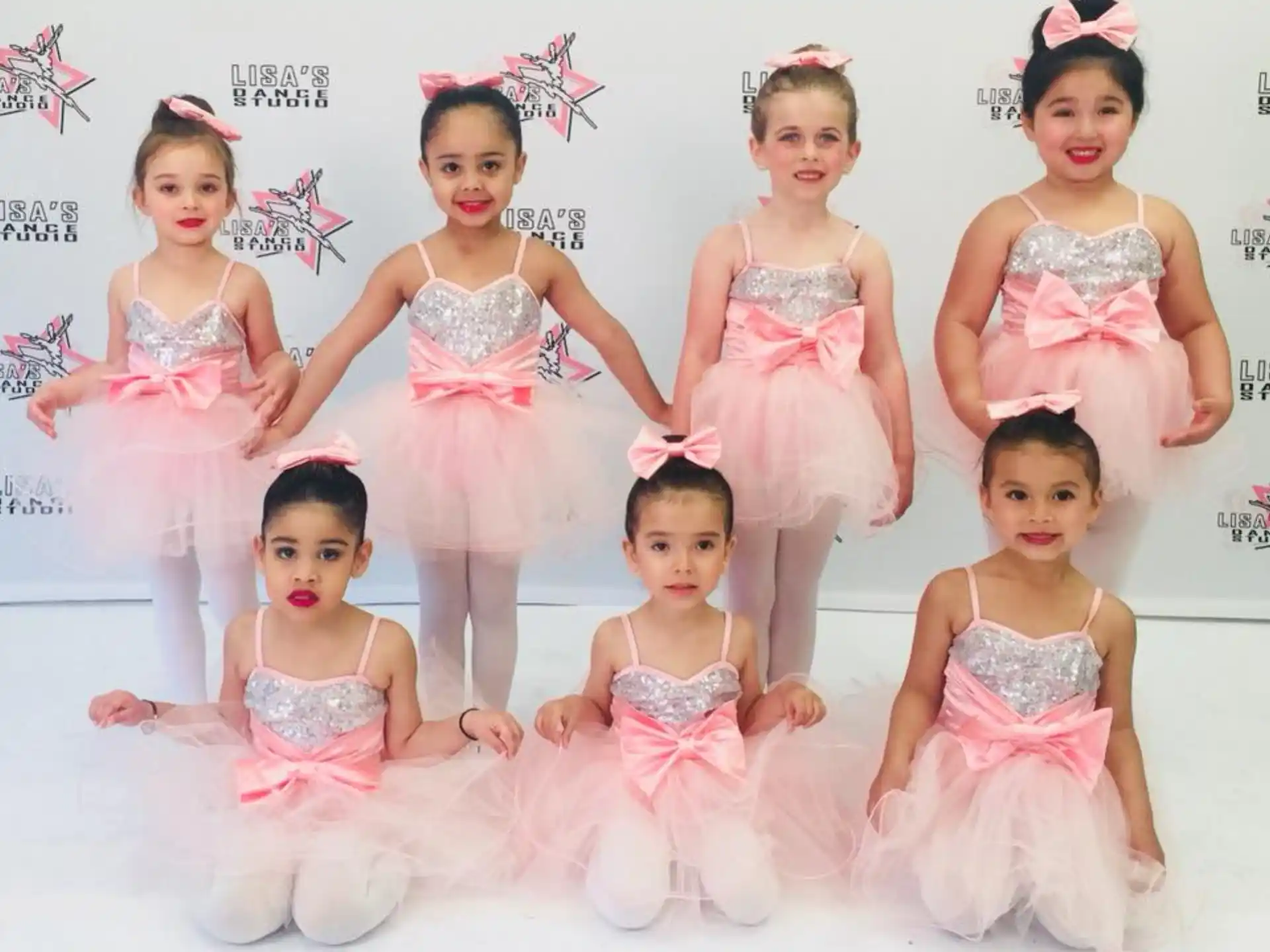 a group of girls in pink dresses