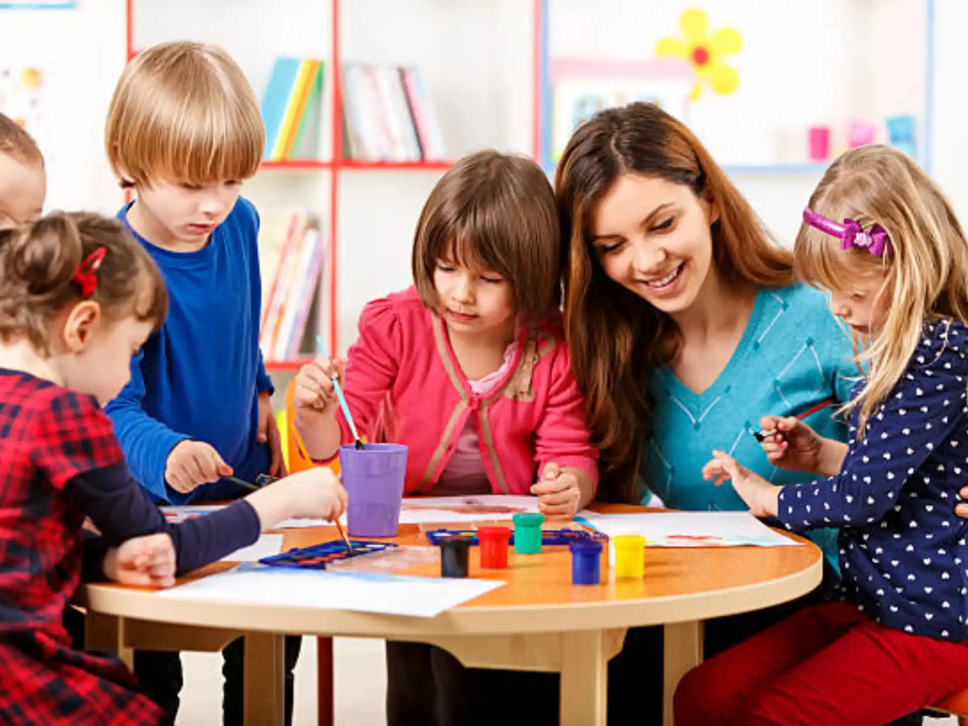 a person and several children sitting at a table