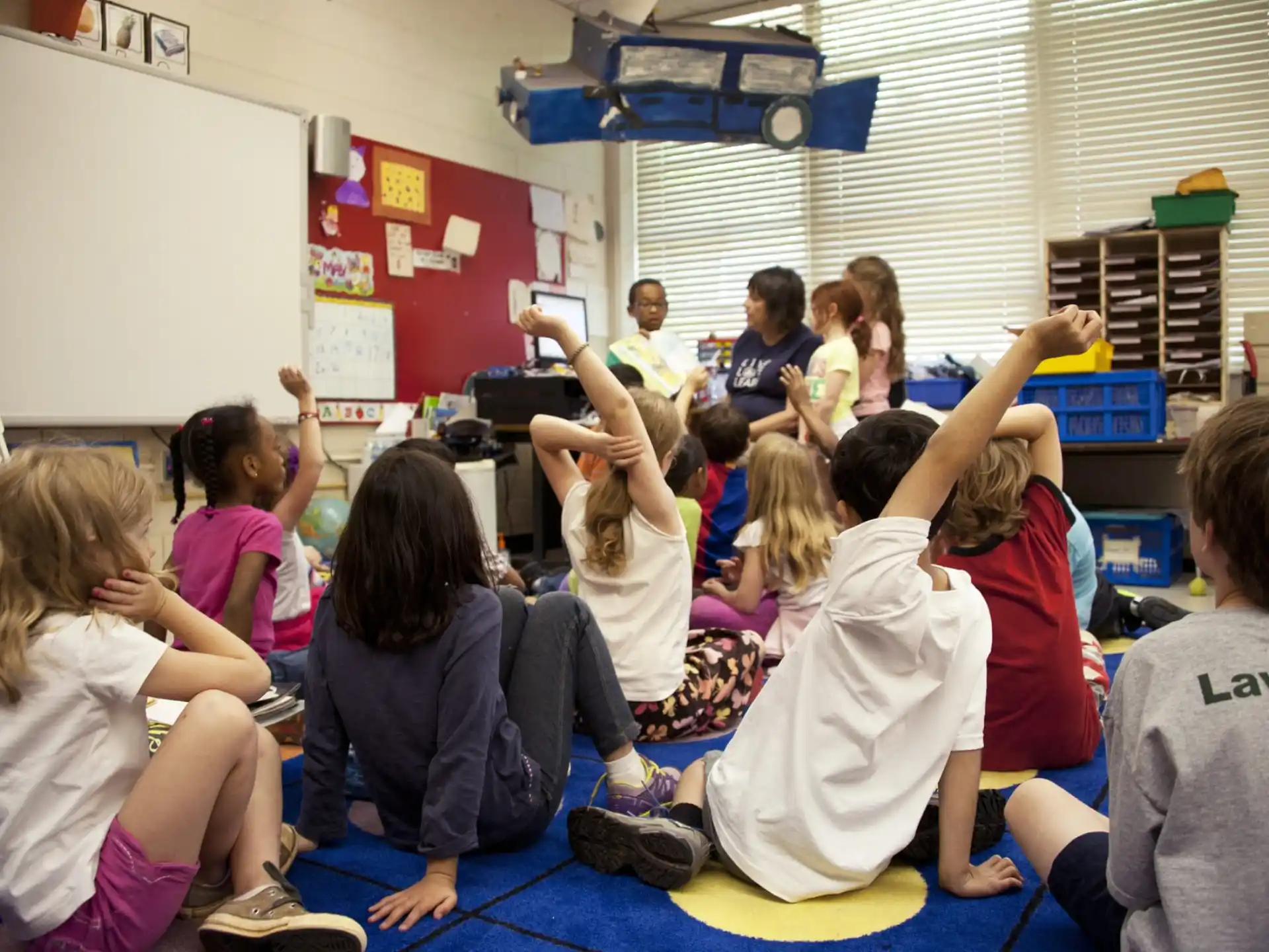 a group of children sitting on the floor in a classroom