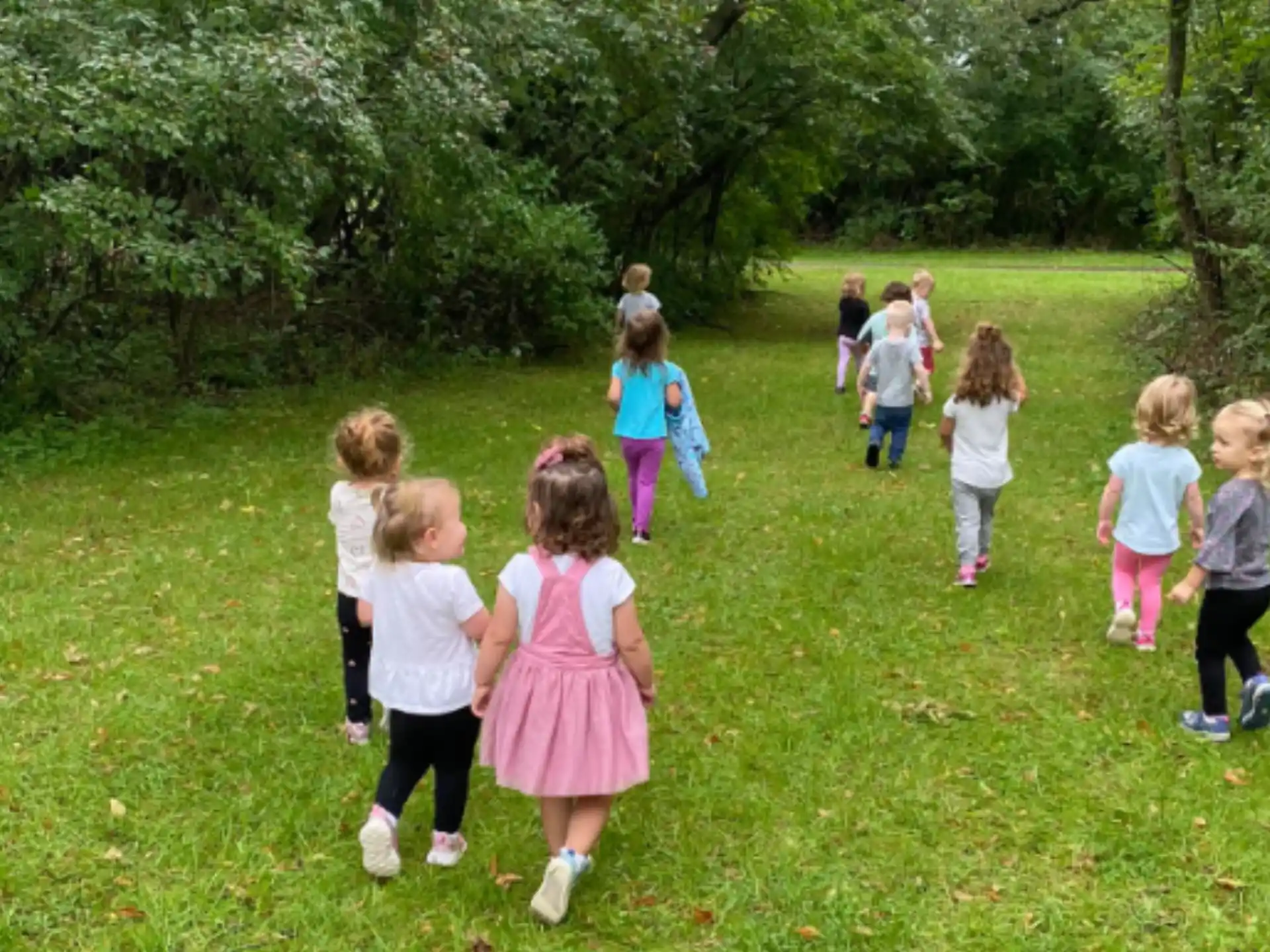 a group of children walking on grass
