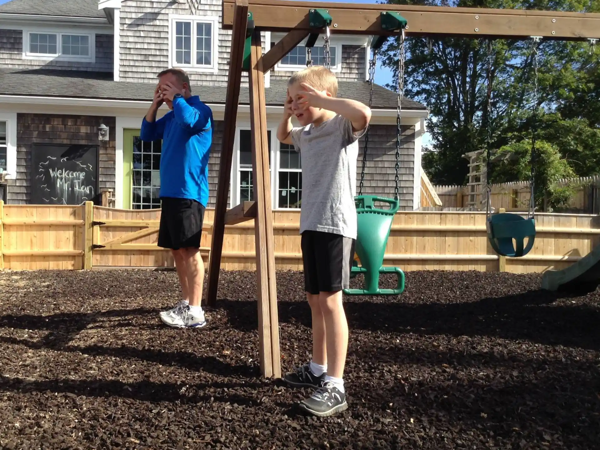 a couple of boys playing on a playground set