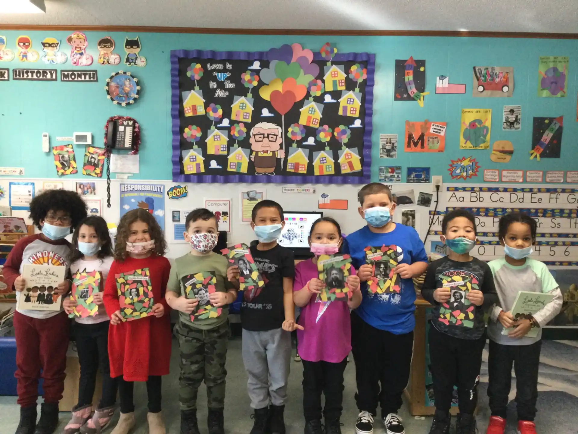 a group of children posing for a photo in front of a wall of art