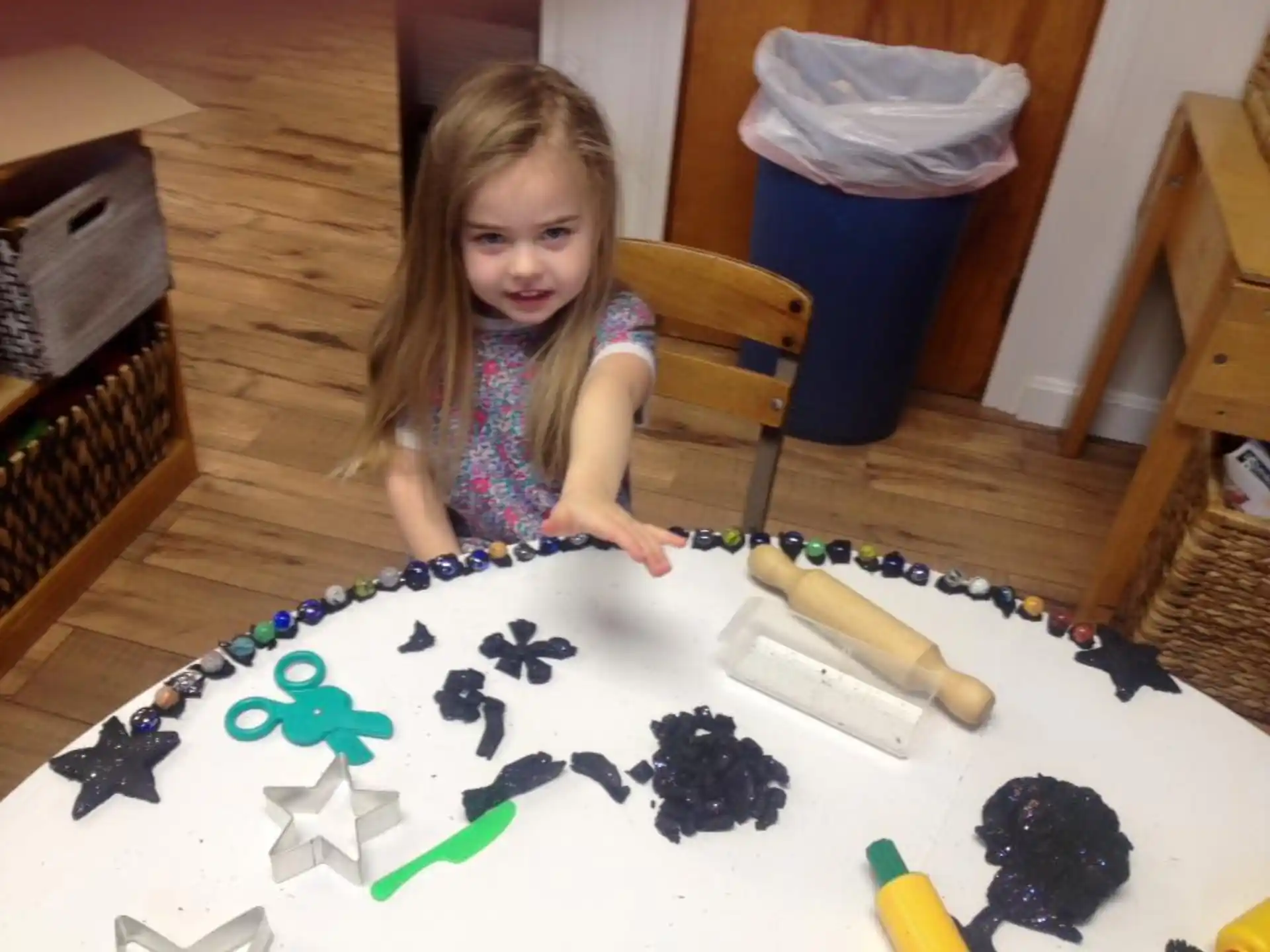 a girl sitting at a table with a cake
