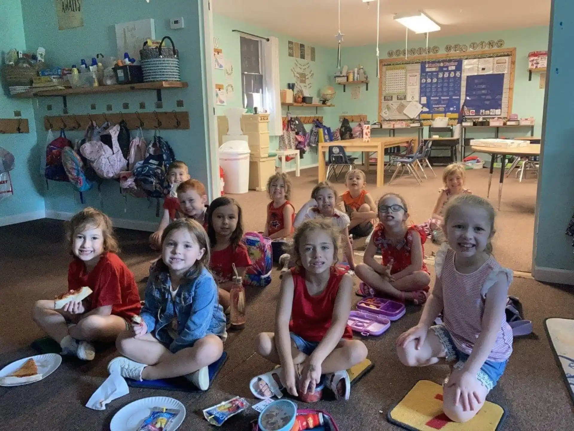 a group of children sitting on the floor in a classroom