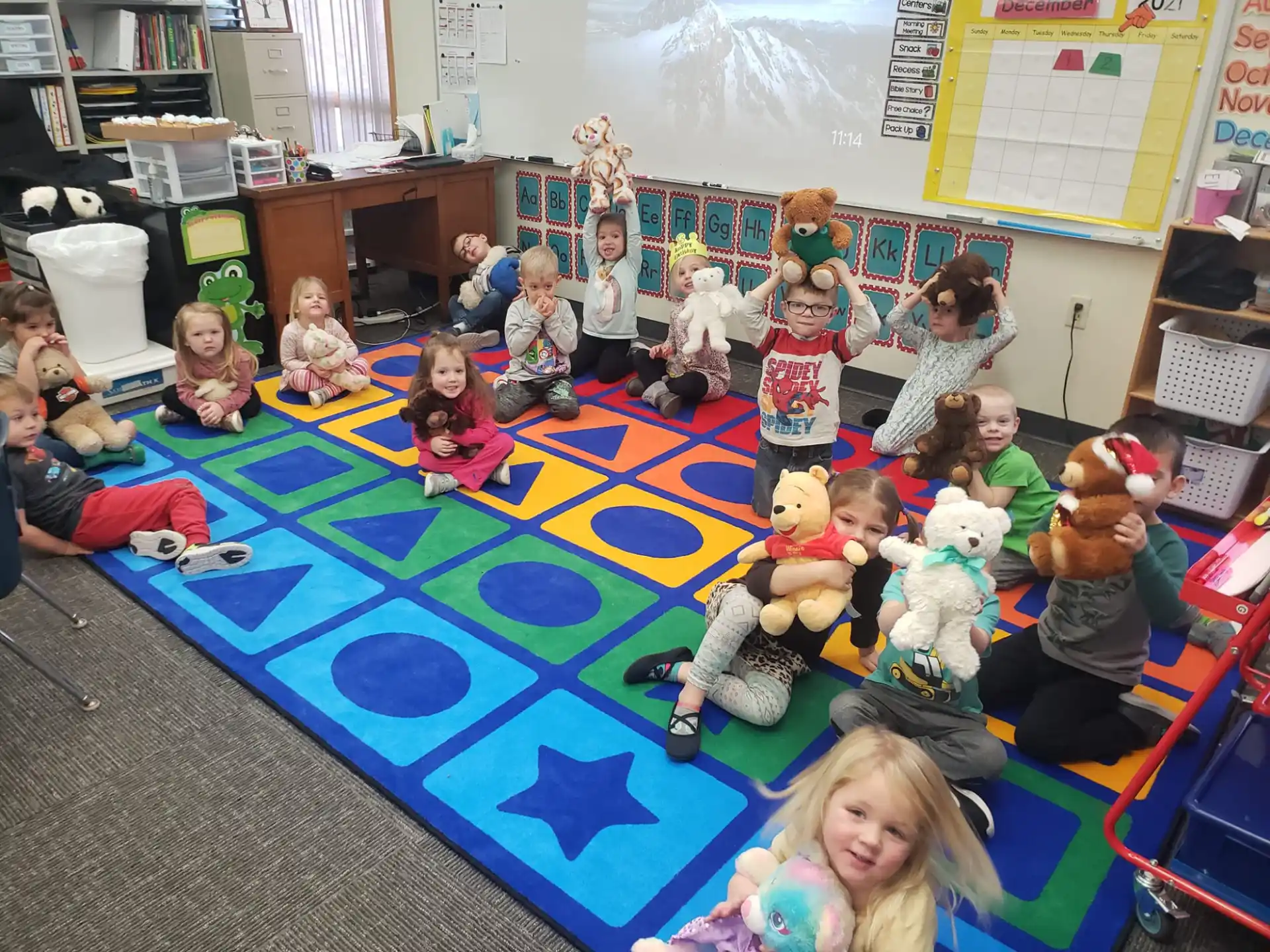 a group of children sitting on the floor with stuffed animals
