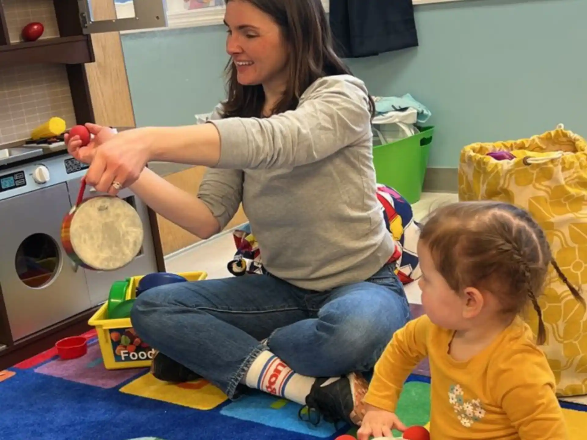 a person and a child playing with toys in a room