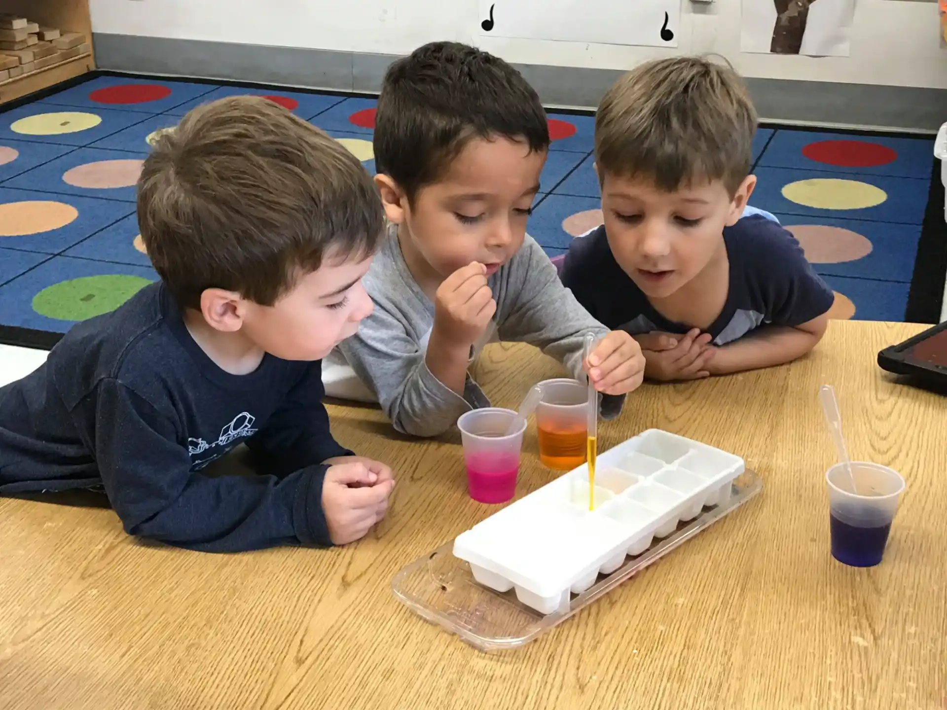 a group of boys sitting at a table with a tray of food